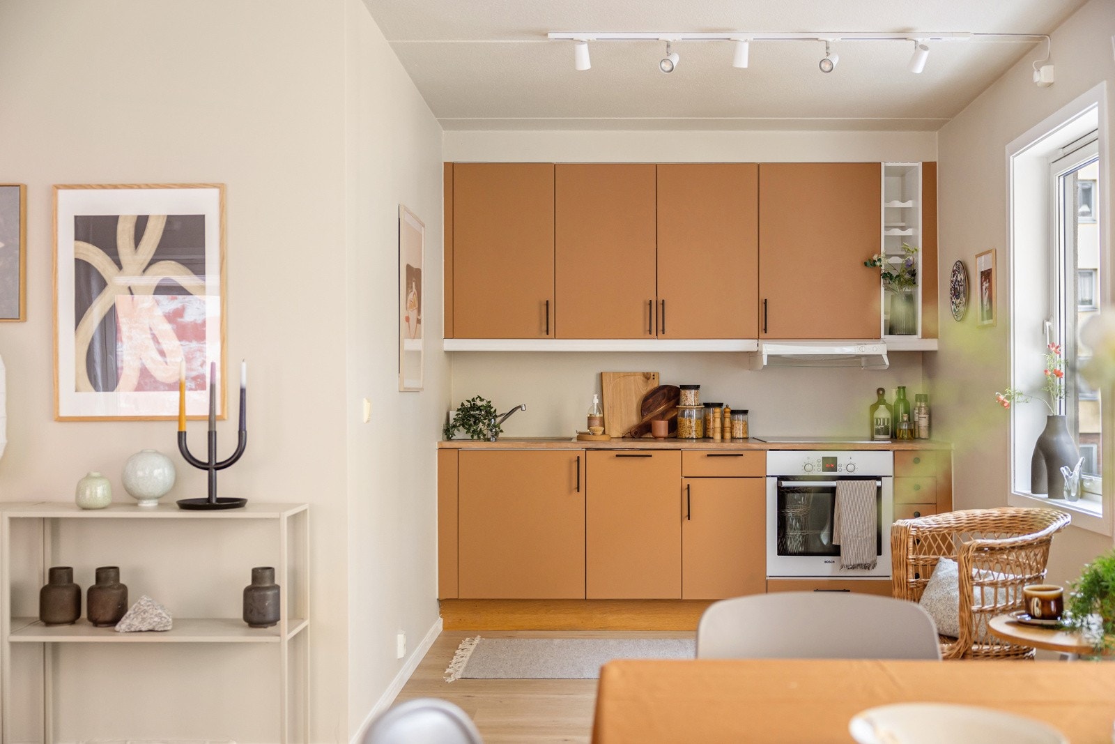 Moderne kjøkkeninnredning med glatte fronter i en fin farge og benkeplate av tre med nedfelt oppvaskkum. Praktisk med belysning under de takhøye overskapene. Galleribilde