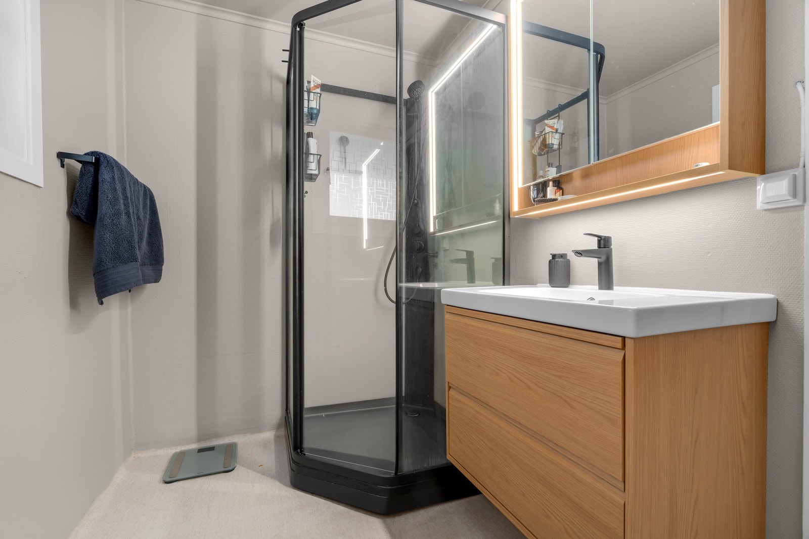 Delikat bad med varme materialvalg og funksjonell planløsning Galleribilde