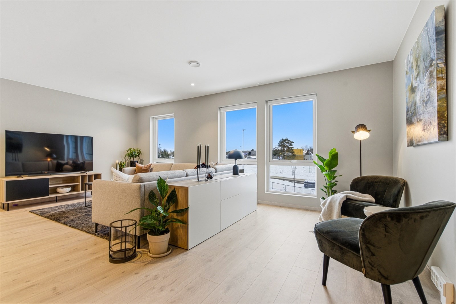 Store vindusflater fyller rommet med dagslys. God plass til sofaløsning med tilhørende møblement. Galleribilde