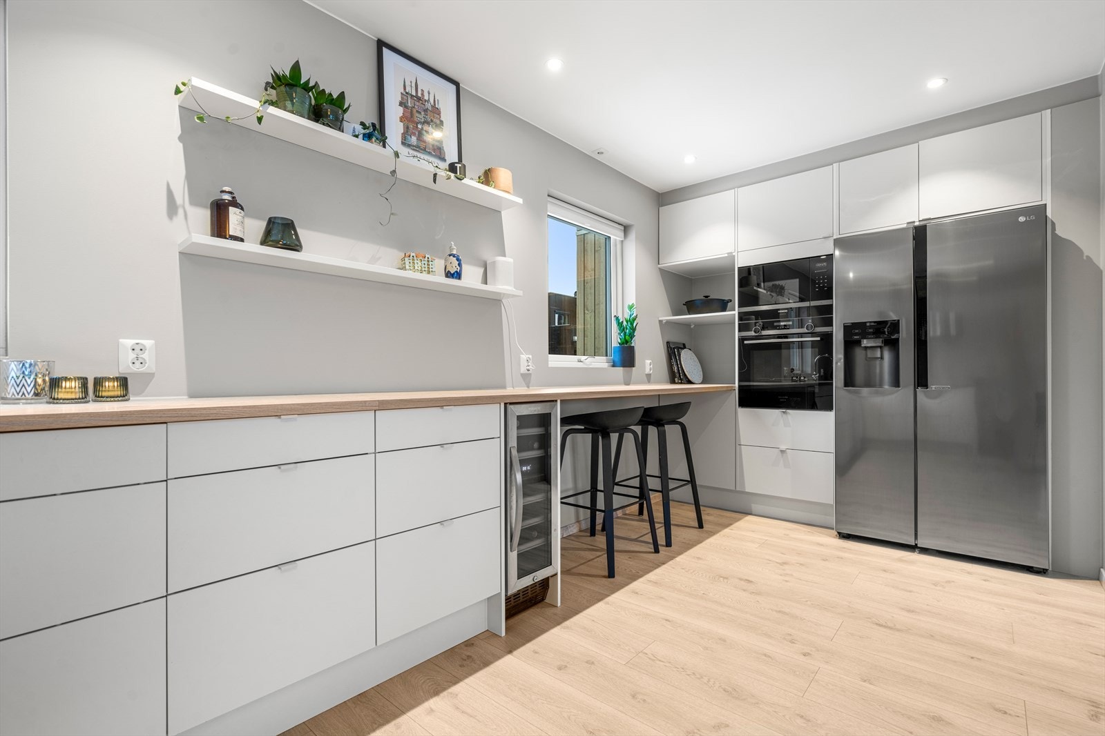 Innredningen har hvite, glatte fronter, laminert benkeplate i treutførelse og nedfelt, underlimt oppvaskkum. Det er montert integrerte hvitevarer, herunder oppvaskmaskin, platetopp, ovn, vinskap og kombiovn. Galleribilde