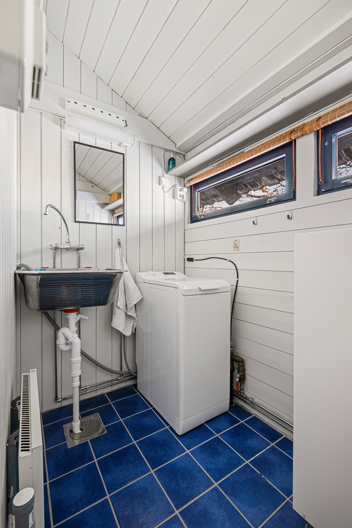 Praktisk vaskerom med flislagt gulv Galleribilde
