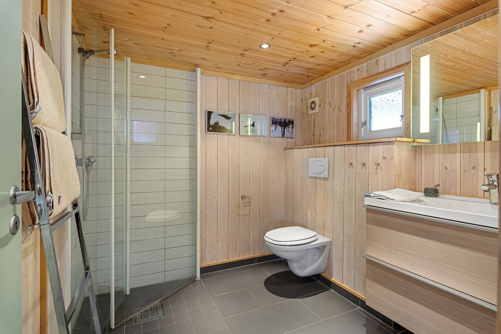 Flott baderom med vegghengt toalett, innredning med servant og dusjhørne med glassdører. Baderommet er oppgradert i 2012 Galleribilde