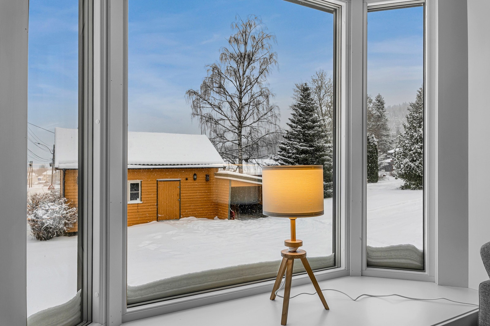 Fra stuevinduet ser man ut over det snødekte tunet og uthuset Galleribilde