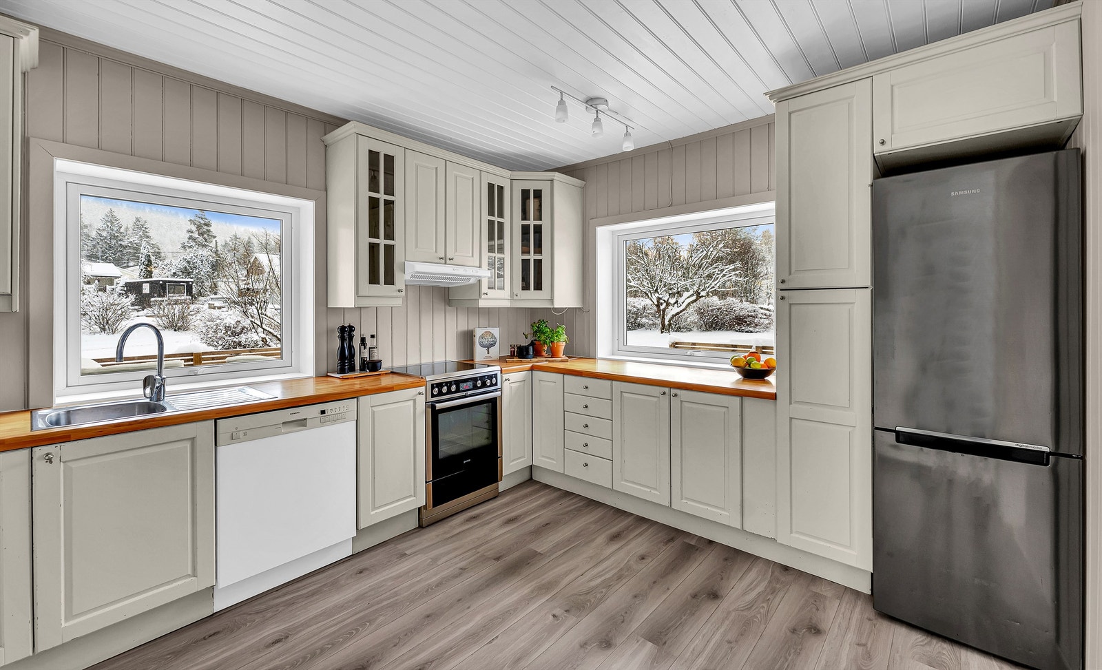 Store vindusflater over arbeidsbenken gir godt med naturlig lys til matlagingen. Galleribilde