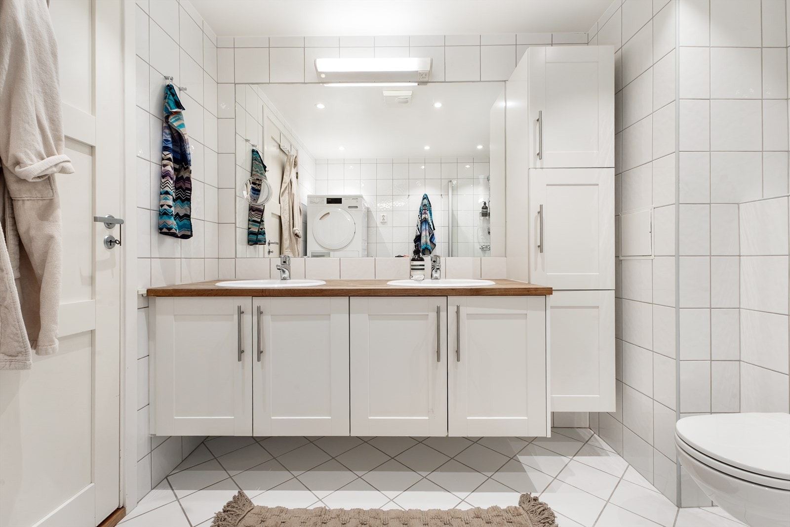 Boligens hovedbad fremstår romslig og funksjonelt, med flislagte overflater og tidløs utførelse. Galleribilde