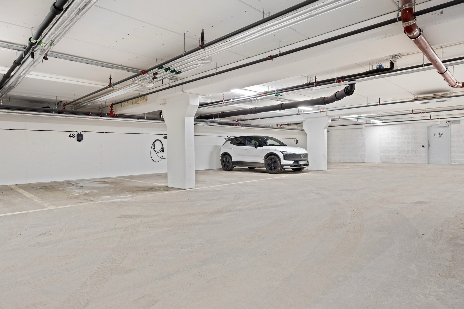 Plass nr. 48 i garasjeanlegget (Neselva Hageby 2 garasjesameie) medfølger i salget. Det er montert ladeboks for el.bil. Herfra er det enkel tilgang til leilighetsnivå med heis eller trapp en etasje opp. Galleribilde