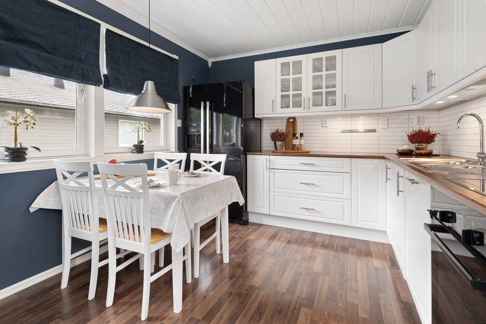 Kjøkkenet har lys innredning med profilerte fronter, benkeplate av laminat og koselig spiseplass ved vinduet. Foto: Espen A. Istad / STUDIO ISTAD Galleribilde