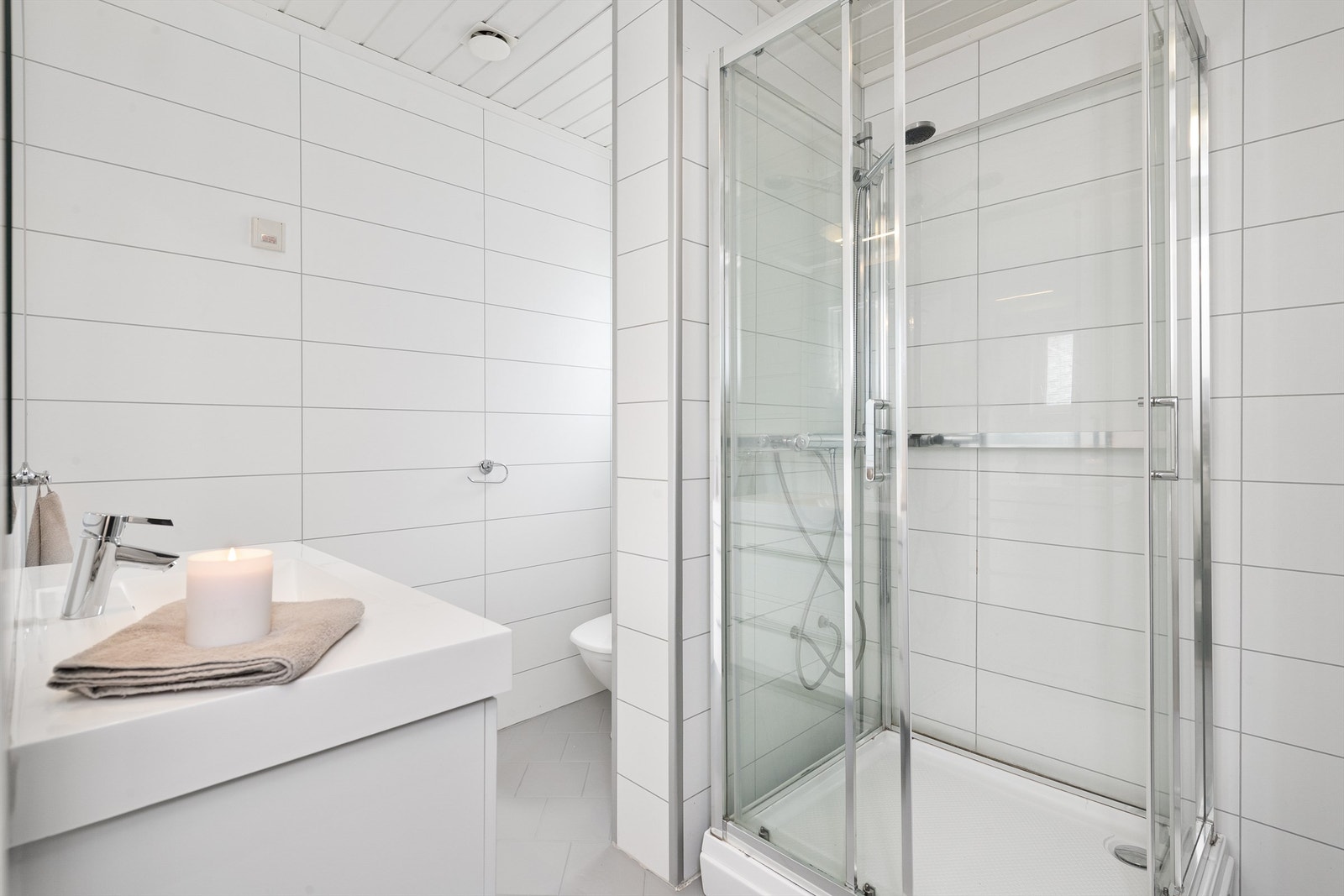 Badet har flis på gulv, baderomsplater på veggene og dusjkabinett. Foto: Espen A. Istad / STUDIO ISTAD Galleribilde