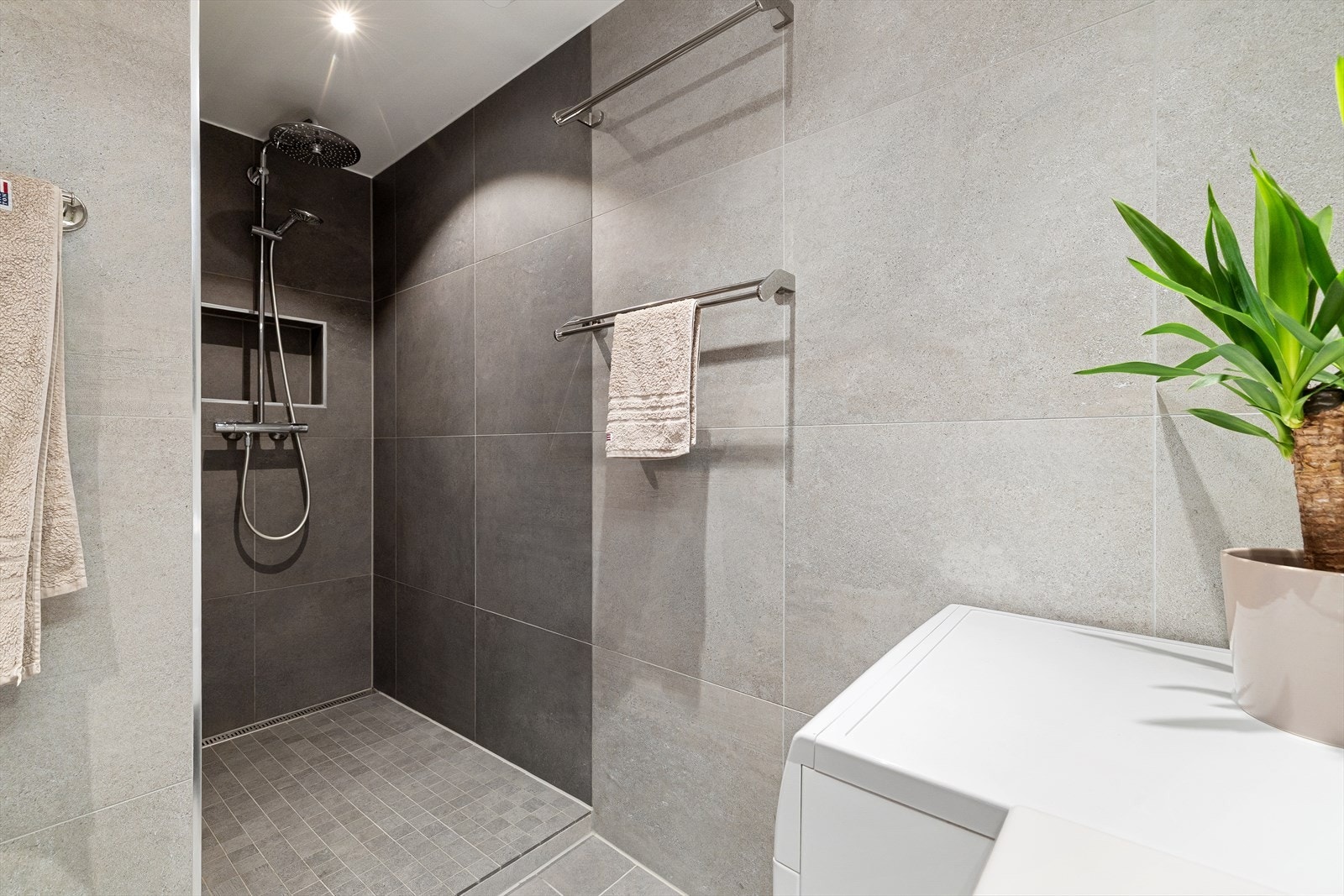 Innredet med vegghengt klosett, baderomsinnredning med heldekkende servant, speilskap m/lys og stor dusjnisje. Galleribilde