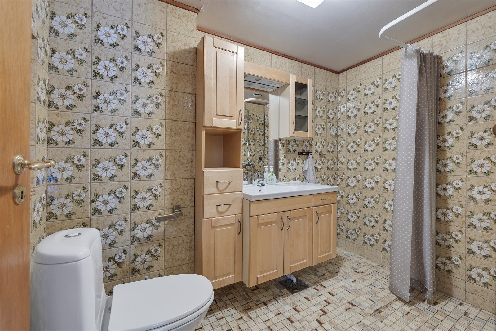 Badet har fliser på både gulv og vegger, samt en innredning med servant og underskap. Galleribilde