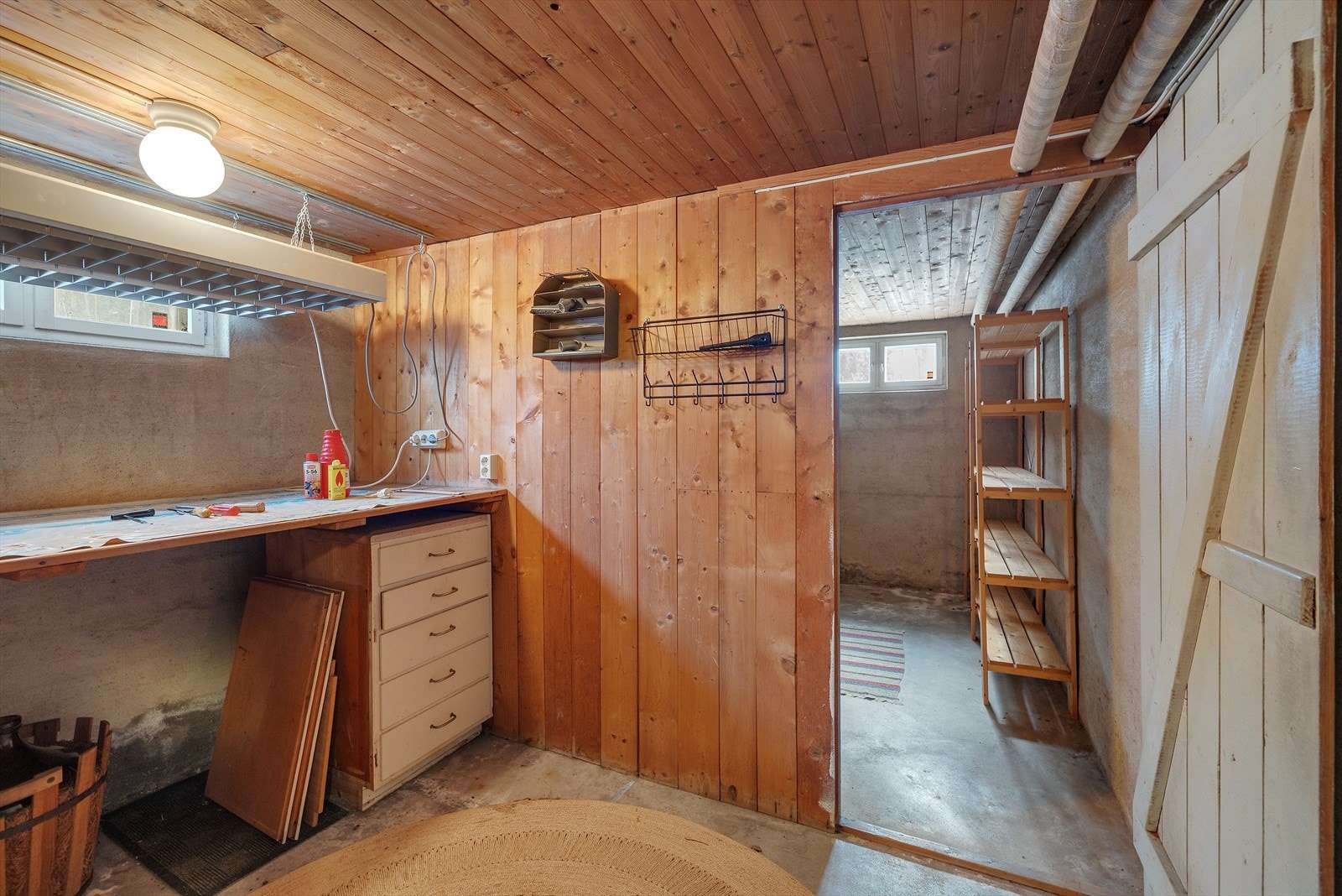 Arbeidsbenk og hyller i tre gir praktisk oppbevaring i kjelleren. Galleribilde
