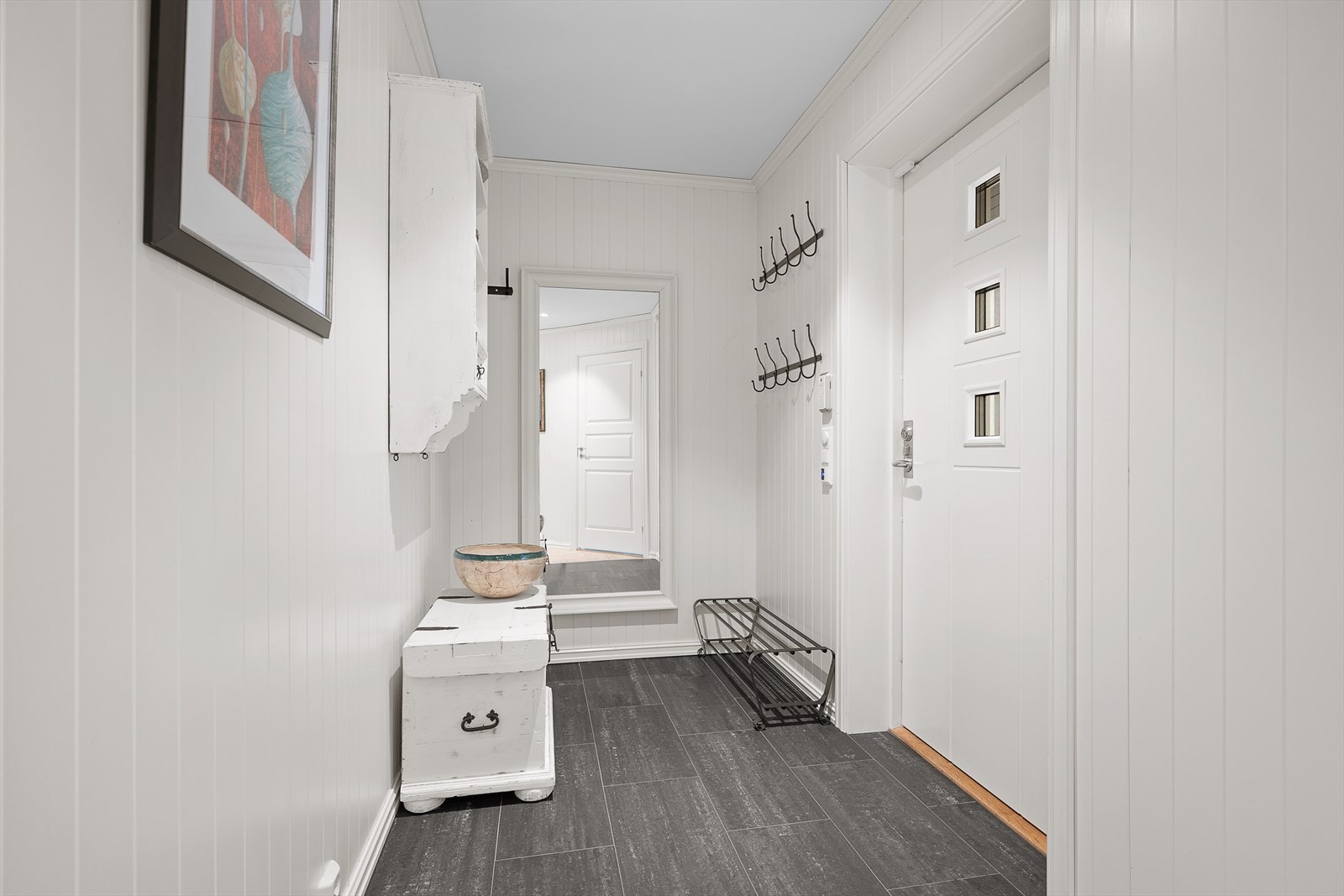 Delikat entré med skiferfarget flis på gulv med varmekabler og hvite flater på veggene Galleribilde