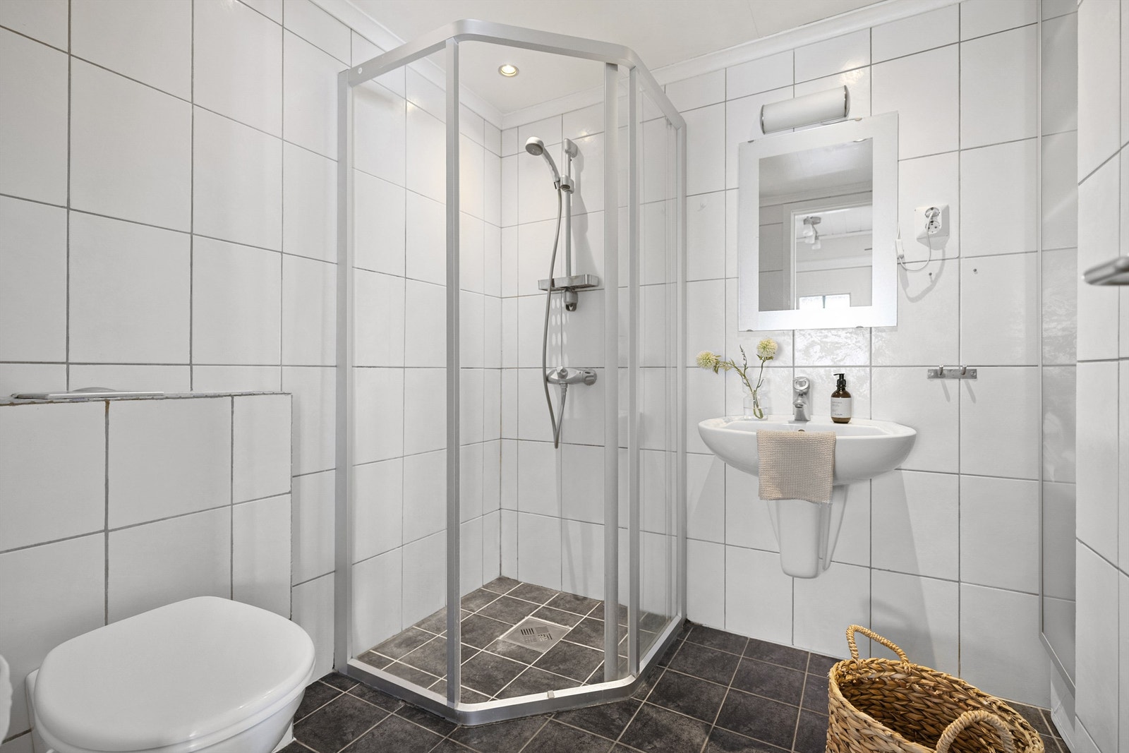 Flott fliselagt bad med dusjnisje og frittstående baderomsmøblement. Galleribilde