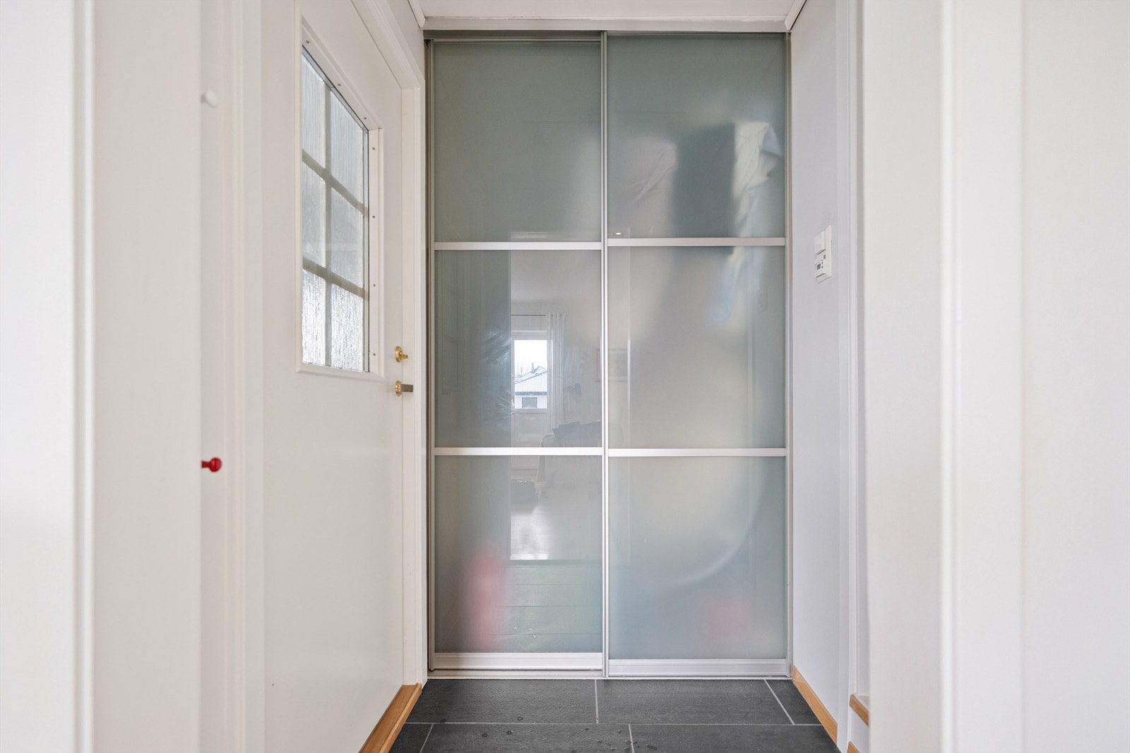 Fliselagt gang med skyvedørsgarderobe. Her er det god plass til yttertøy og sko. Galleribilde