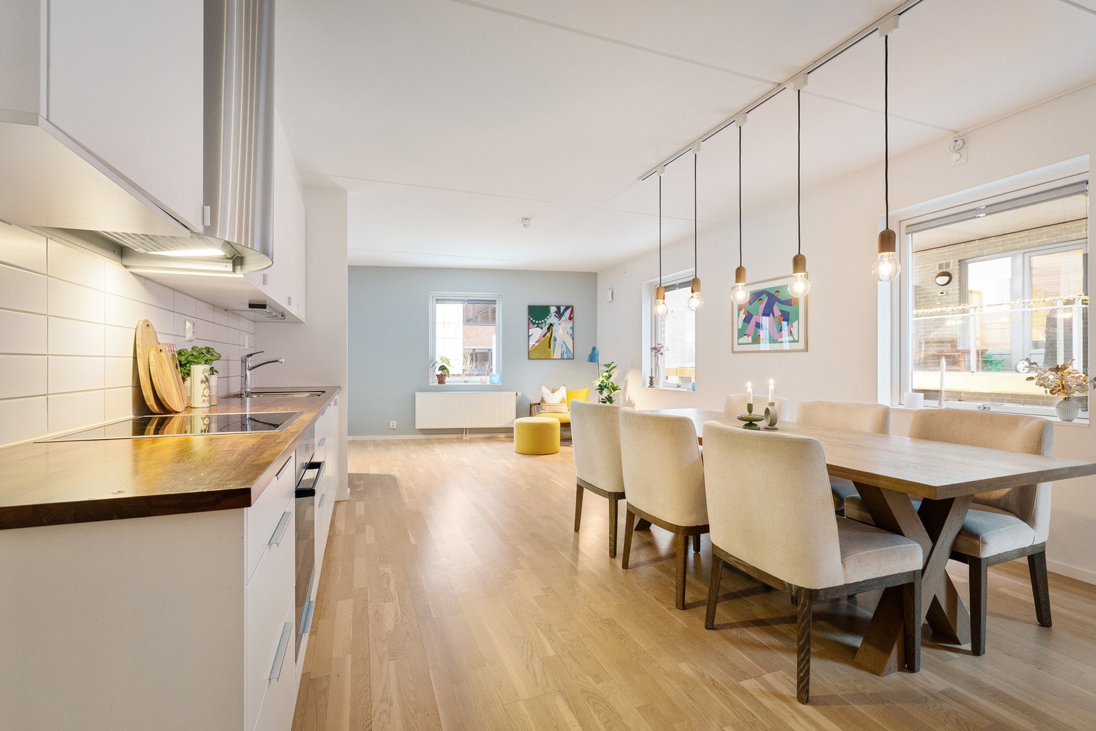 Løsningen skaper et sosialt og lyst oppholdsrom med naturlige soner for både spiseplass og sofagruppe. Galleribilde