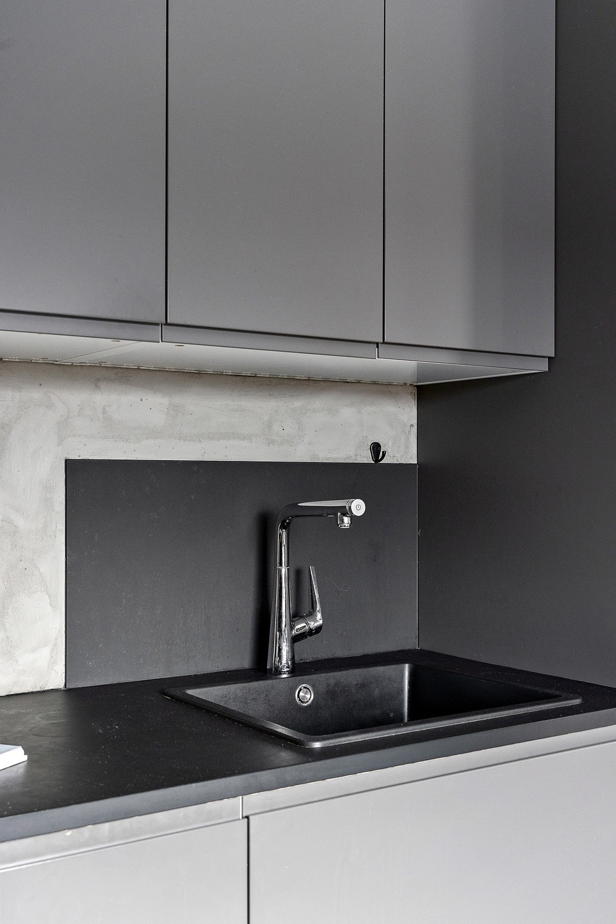Grå fronter og mørke benkeplater setter et moderne og stilfullt preg på kjøkkenet. Galleribilde
