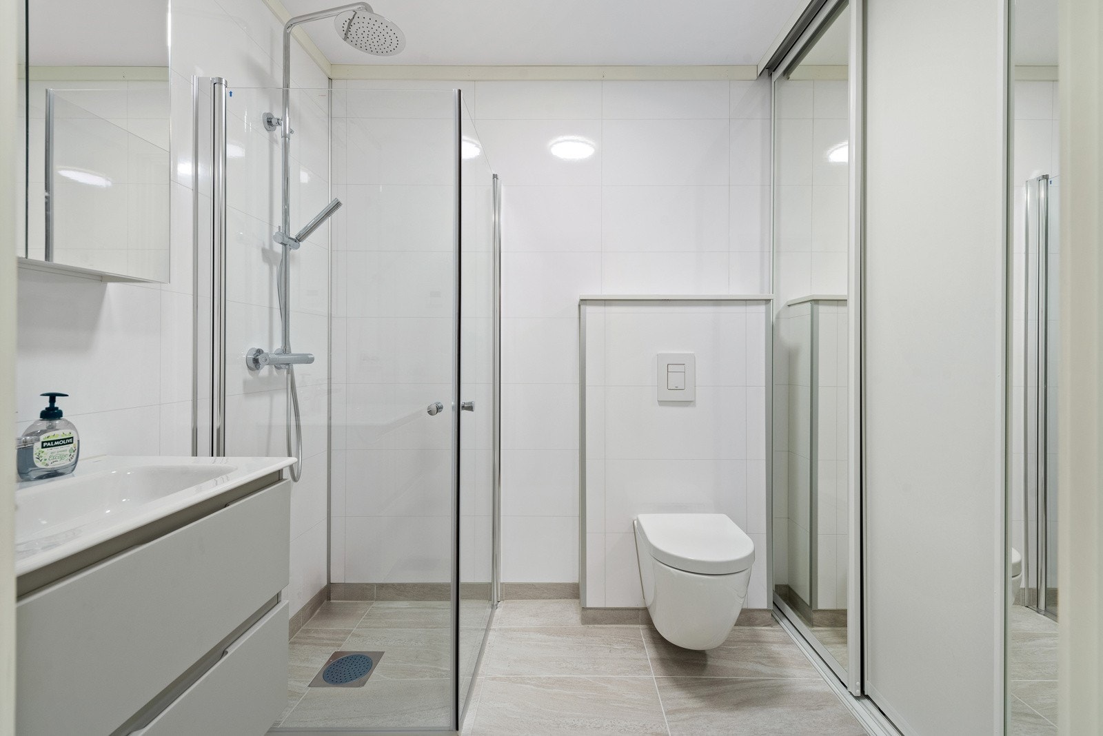 Bad med vaskeromsløsning skjult bak skyvedører i 1.etg. Badet har fliser på gulv med vannbåren varme. Galleribilde