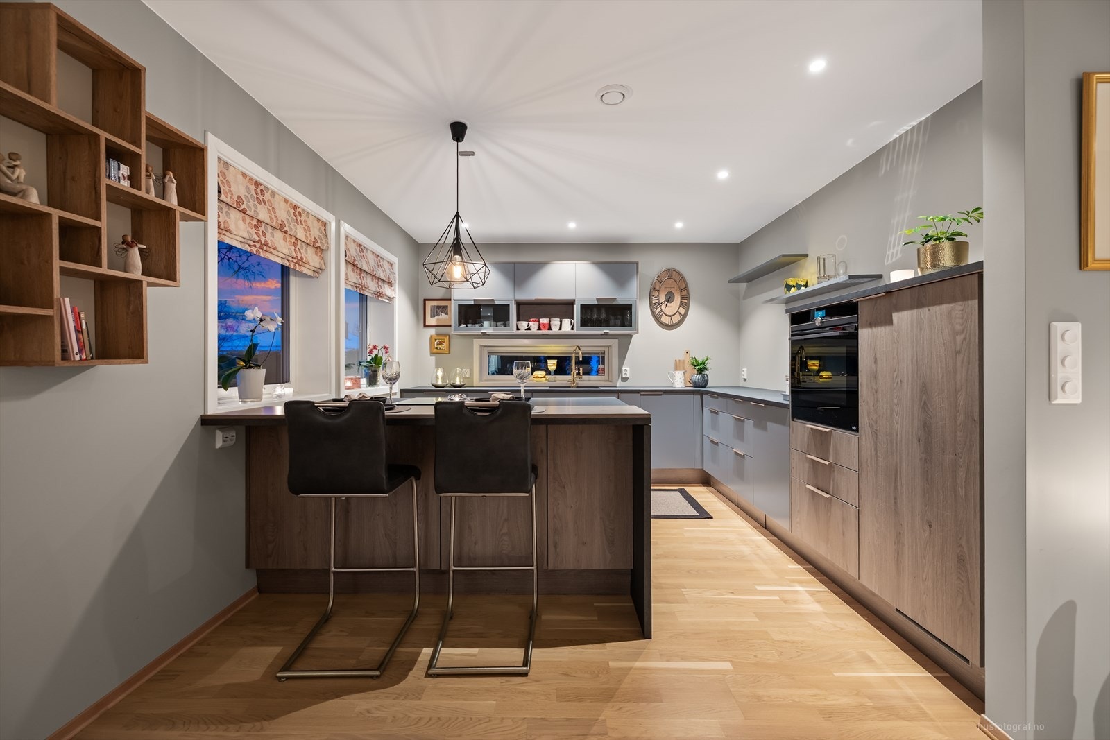 Den praktiske barløsningen fungerer som et naturlig samlingspunkt i kjøkkenet og skaper en sosial sone mellom matlaging og opphold. Galleribilde