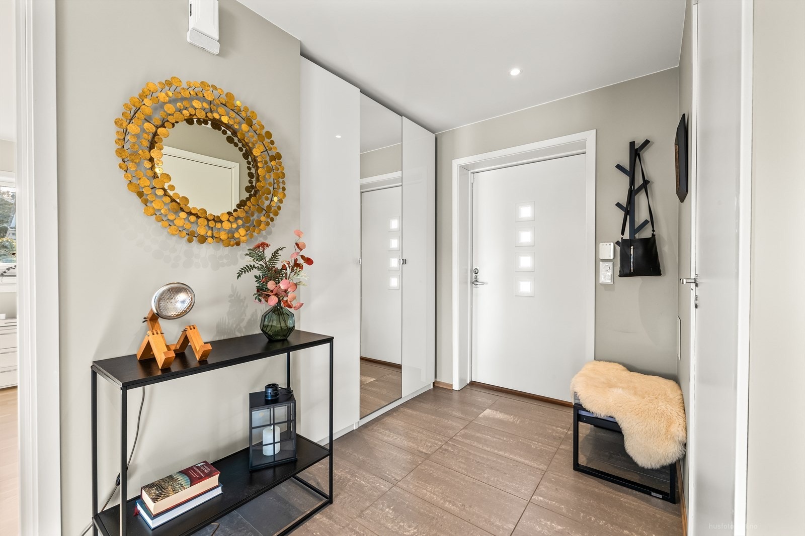 Lys og romslig flislagt entré med god plass til å henge ifra seg yttertøyet og til å sette fra seg sko i garderobe. Galleribilde