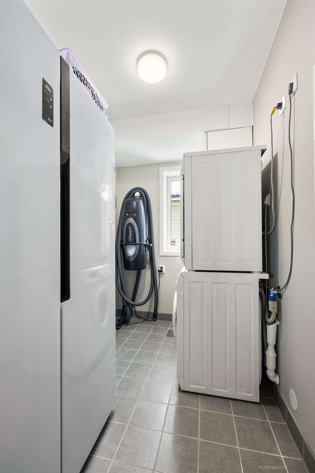 Praktisk vaskerom med opplegg for vaskemaskin og tørketrommel. Boligen har også sentralstøvsuger. Galleribilde