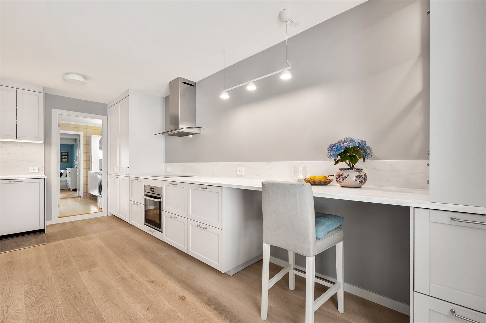 Kjøkkeninnredningen har lyse fronter og skaper en god harmoni i rommet. Her har man rikelig med benkeplass til matlaging Galleribilde