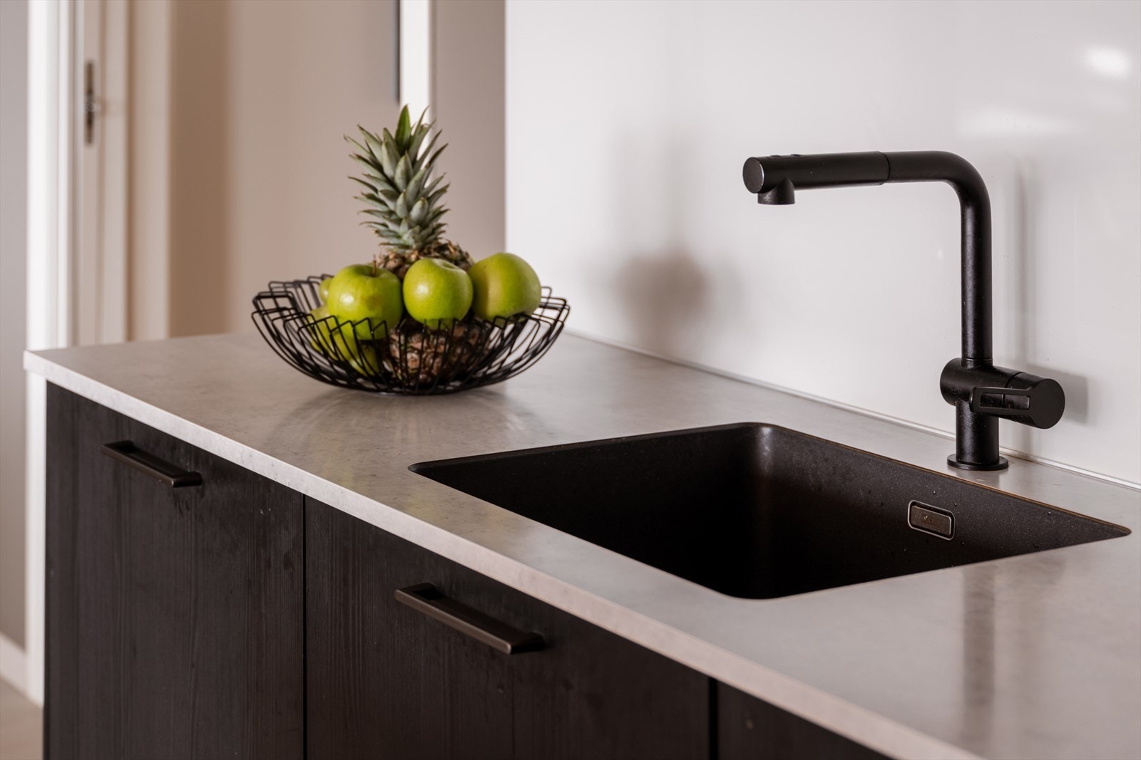 Detaljer som nedfelt vask og moderne armatur understreker den gjennomførte stilen. Galleribilde