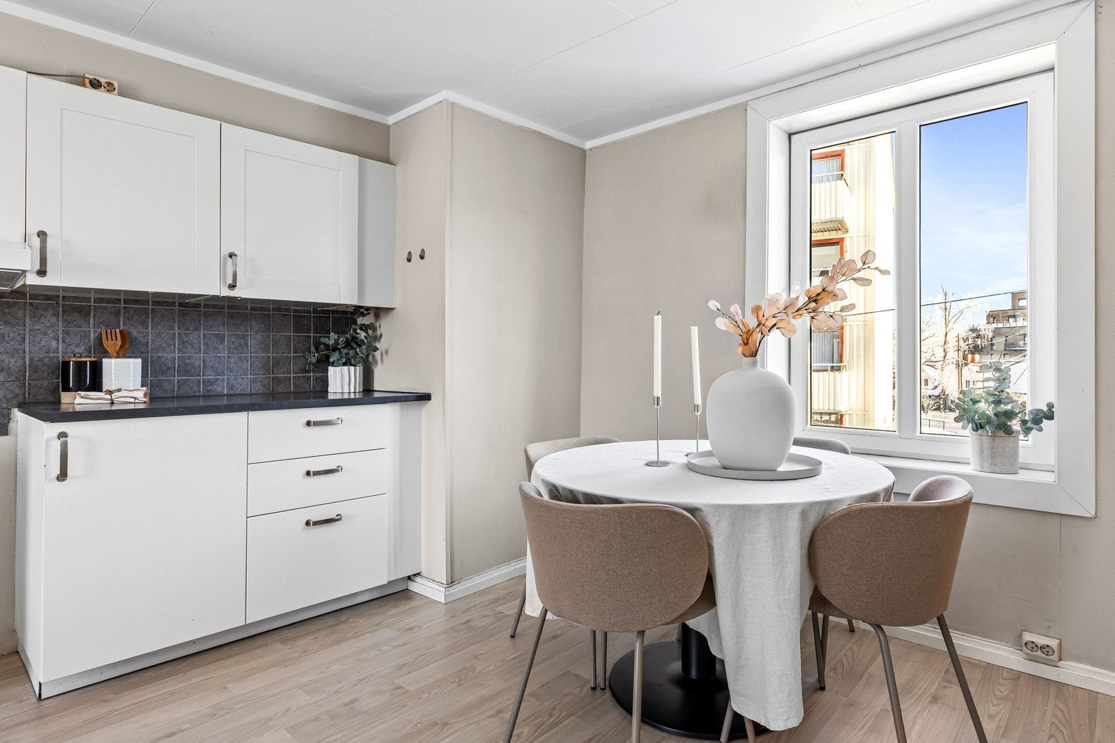 Kjøkkenet er utstyrt med innredning med enspeils fronter, overskap og fliser over benk. Galleribilde