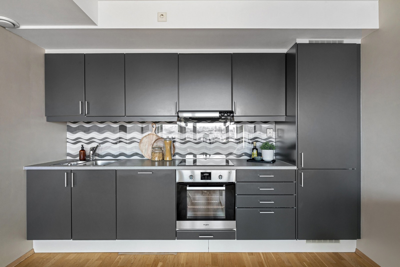 Kjøkkenet har et sømløst uttrykk med integrert oppvaskmaskin, kjøl/fryseskap, stekeovn og keramisk platetopp. Galleribilde