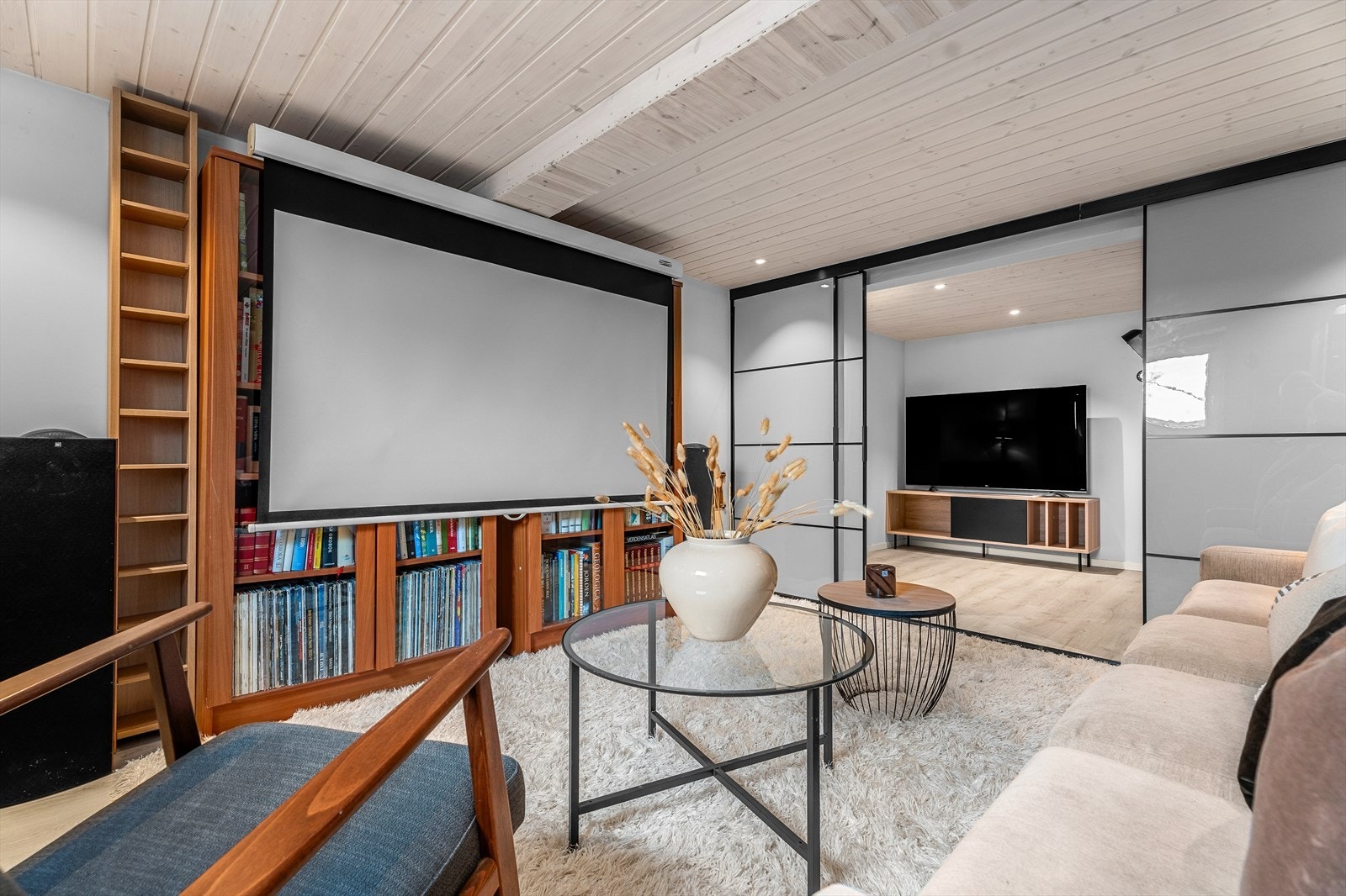 Kjellerstuen adskilles av moderne skyvedører som bidrar til en utvidelse av stuen ved ønske. Galleribilde