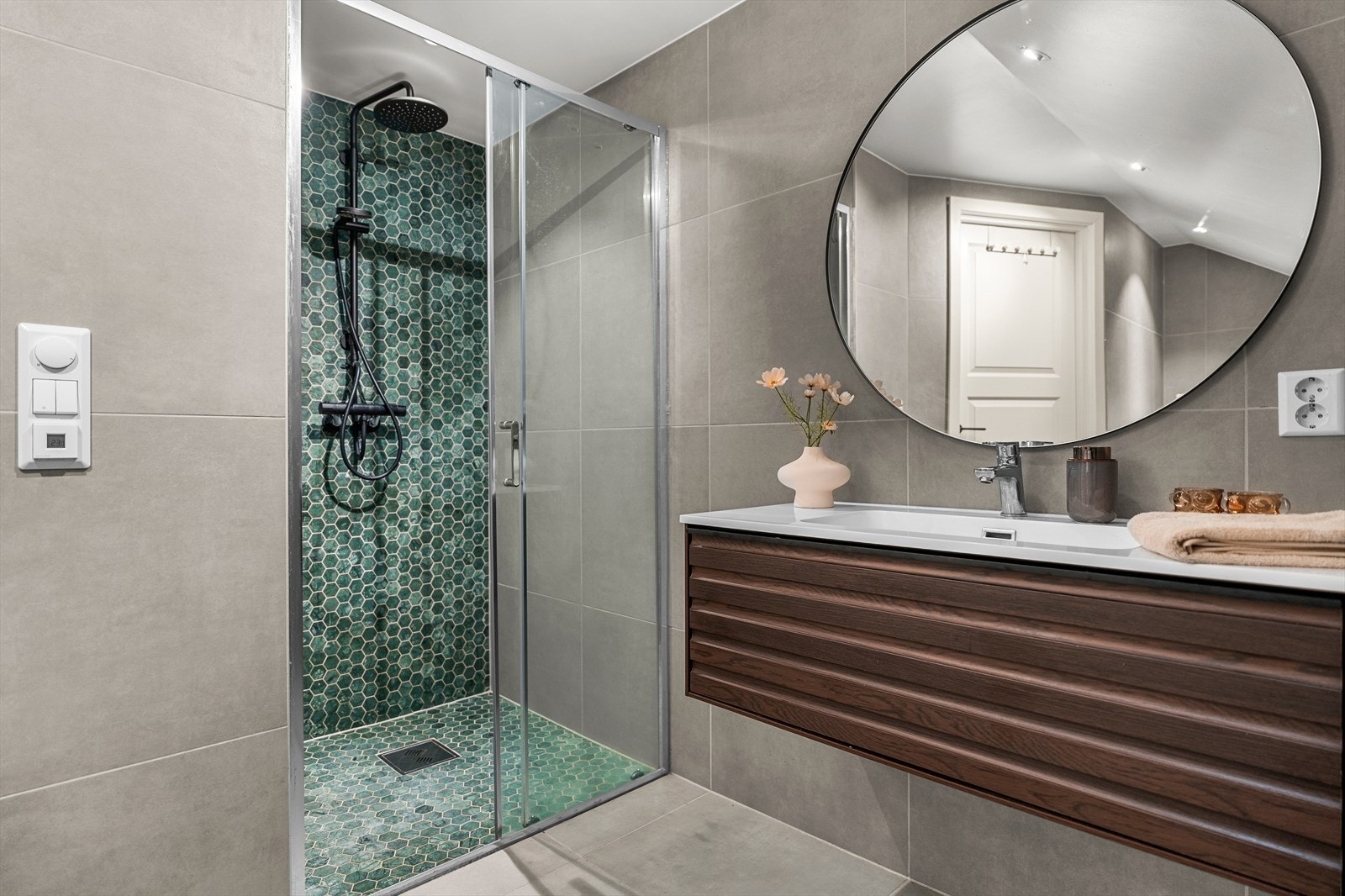 Badet på loftet er hellagt i lekre 60x60 fliser og byr på behagelig varme i gulv. Det er også opplegg for vaskemaskin, og rikelig med plass til både vaskemasin og tørketrommel. Galleribilde