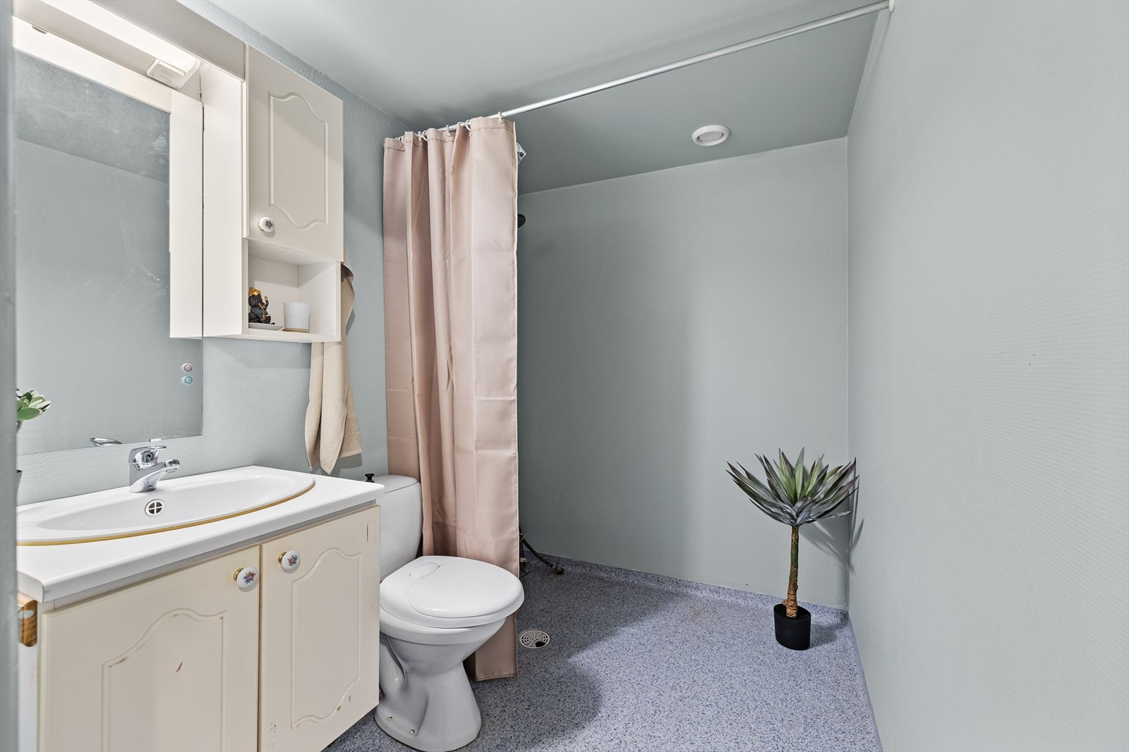 Eldre bad med servant i innredning, gulvmontert toalett og dusjhjørne. Badet vil på sikt ha behov for totalrenovering. Plass for vaskemaskin Galleribilde