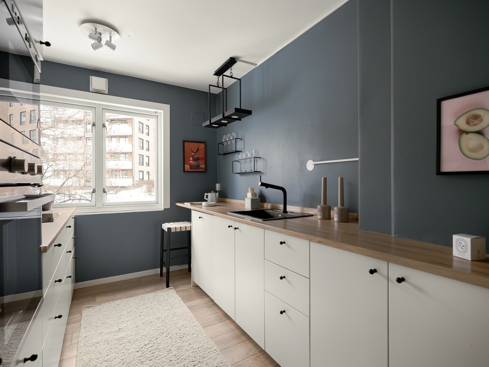 Slettmalte vegger og laminatgulv gir en moderne finish til kjøkkenet. Galleribilde