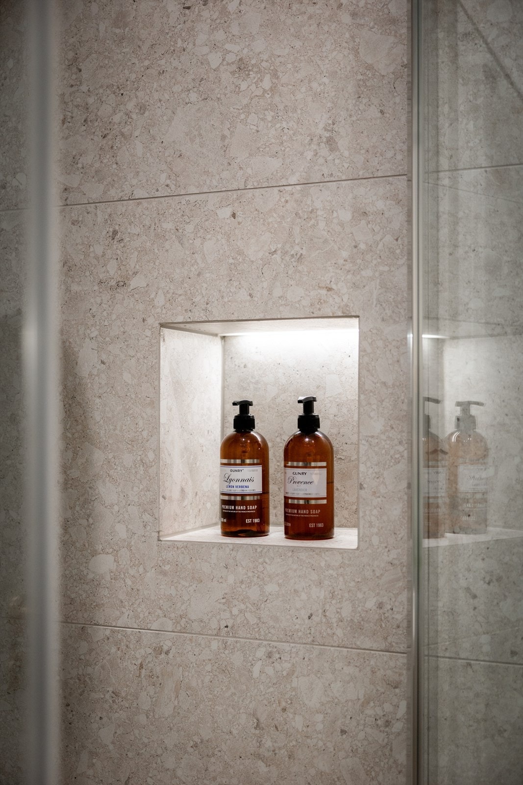 Dusjen er plassert i hjørnet og har håndholdt dusjarmatur, nisje og dusjvegger. Galleribilde