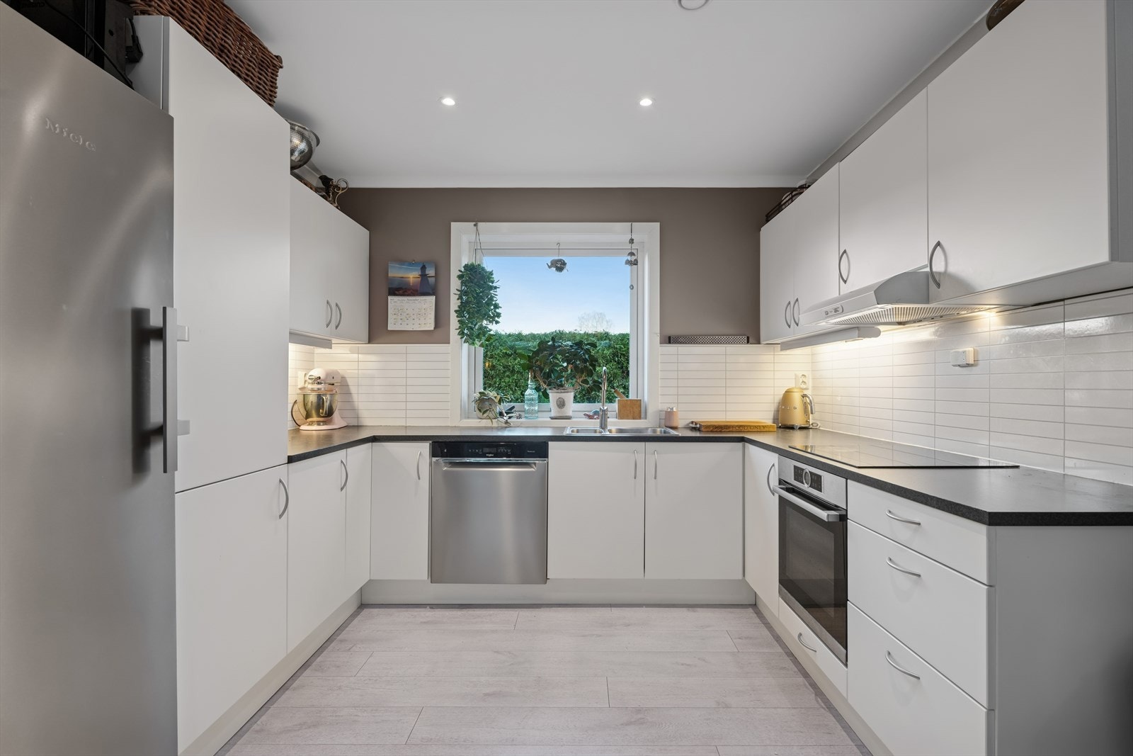 Det flotte kjøkkenet byr på en moderne kjøkkeninnredning og har flere flotte detaljer som platetopp nedfelt i benkeplate, øvrige hvitevarer og meget god benk- og skapplass. Galleribilde