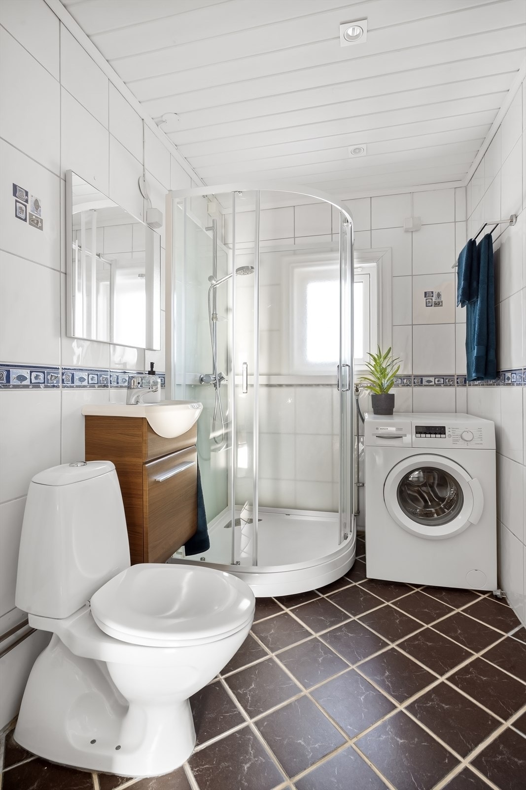 Badet er innredet med servant, speil, høyskap og toalett. Galleribilde