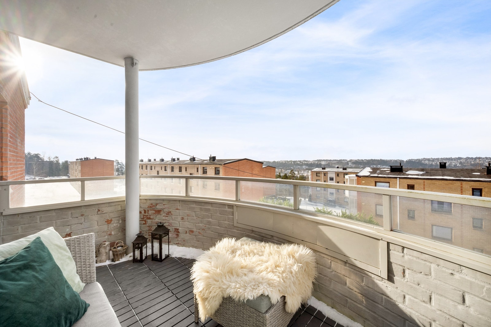 Balkongen har gulv belagt med plastfliser og en åpen utsikt over nærområdet. Galleribilde