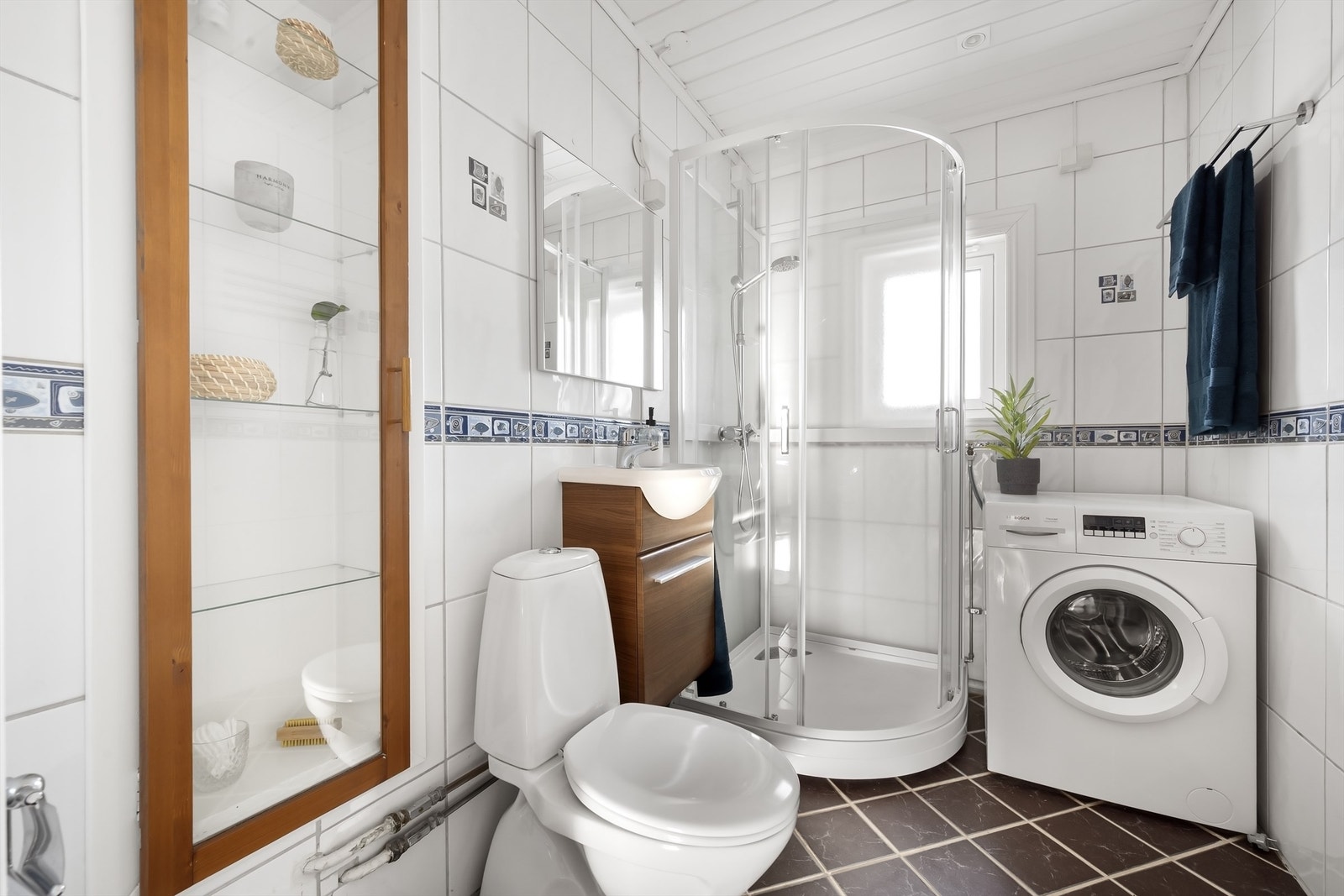 Flislagt bad med gulvvarme, dusjkabinett og opplegg for vaskemaskin. Galleribilde