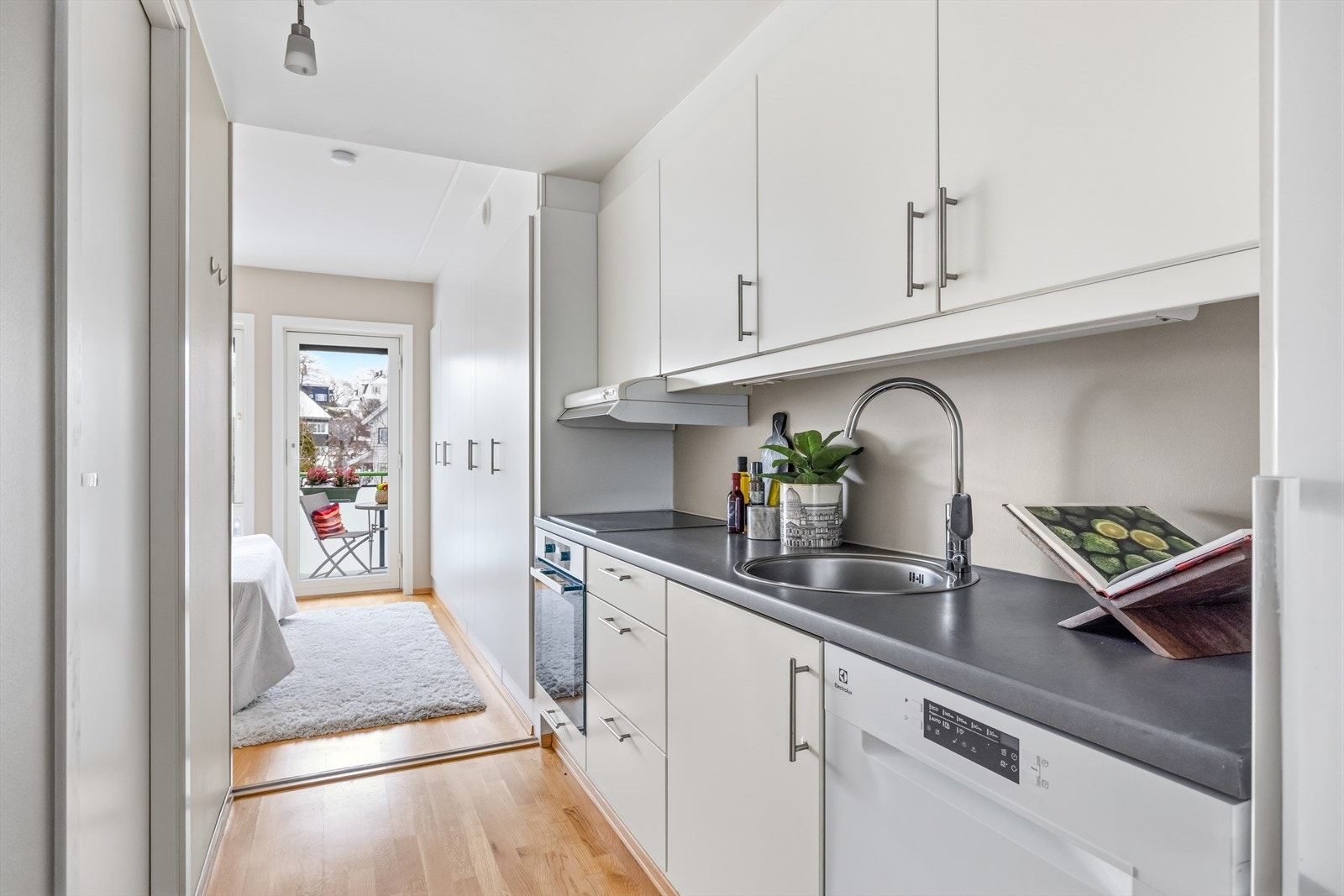 Kjøkkenet er fra 2010 og har en stilren utforming med slette, hvite fronter og en mørk laminert benkeplate som gir en fin kontrast Galleribilde