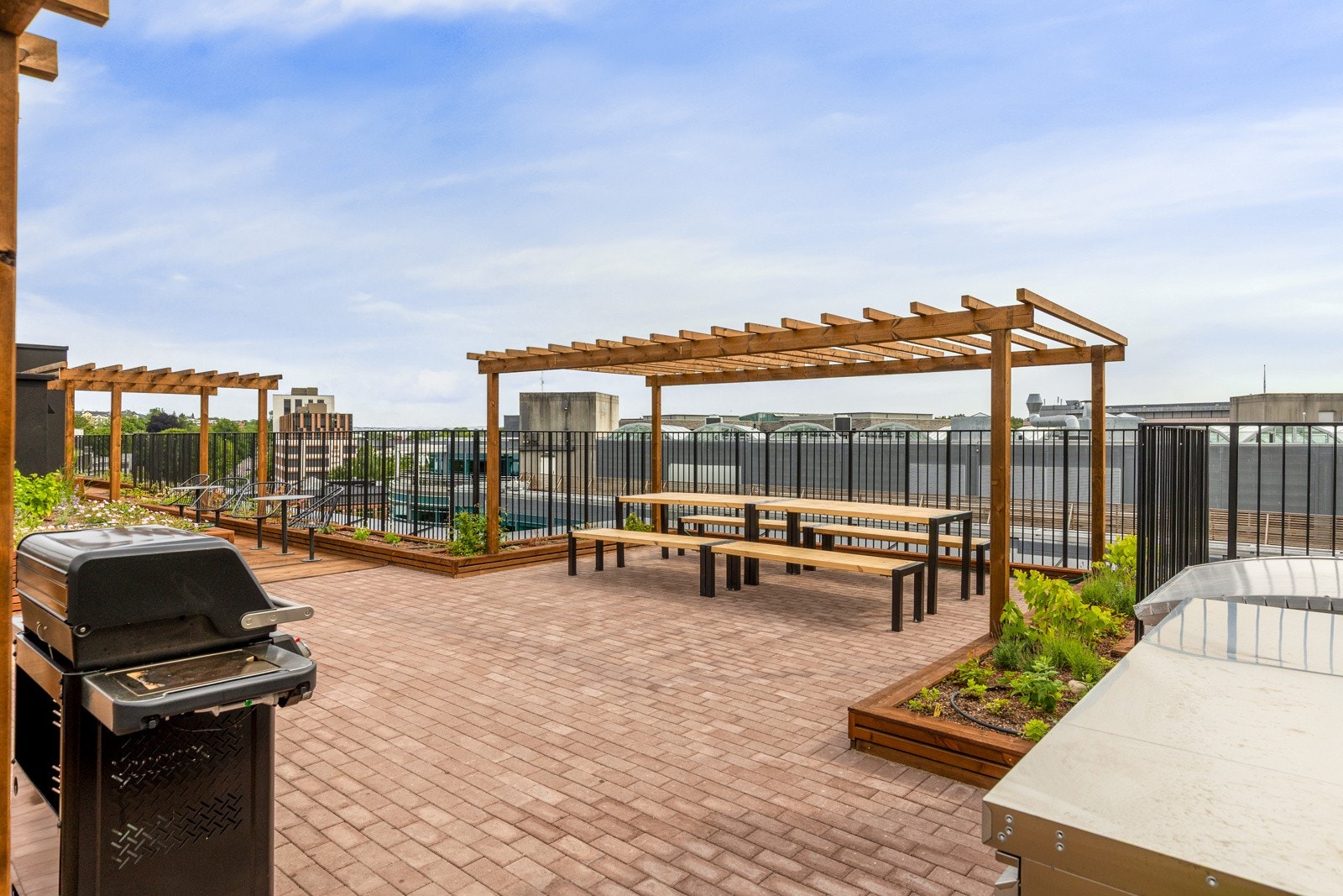 Stor felles takterrasse med grill, utemøbler og solsenger Galleribilde