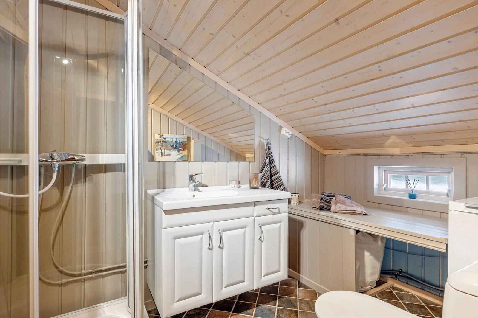 Badet har flislagt gulv med varmekabler, og veggene er kledd med malt panel. Himlingen består av beiset panel. Galleribilde