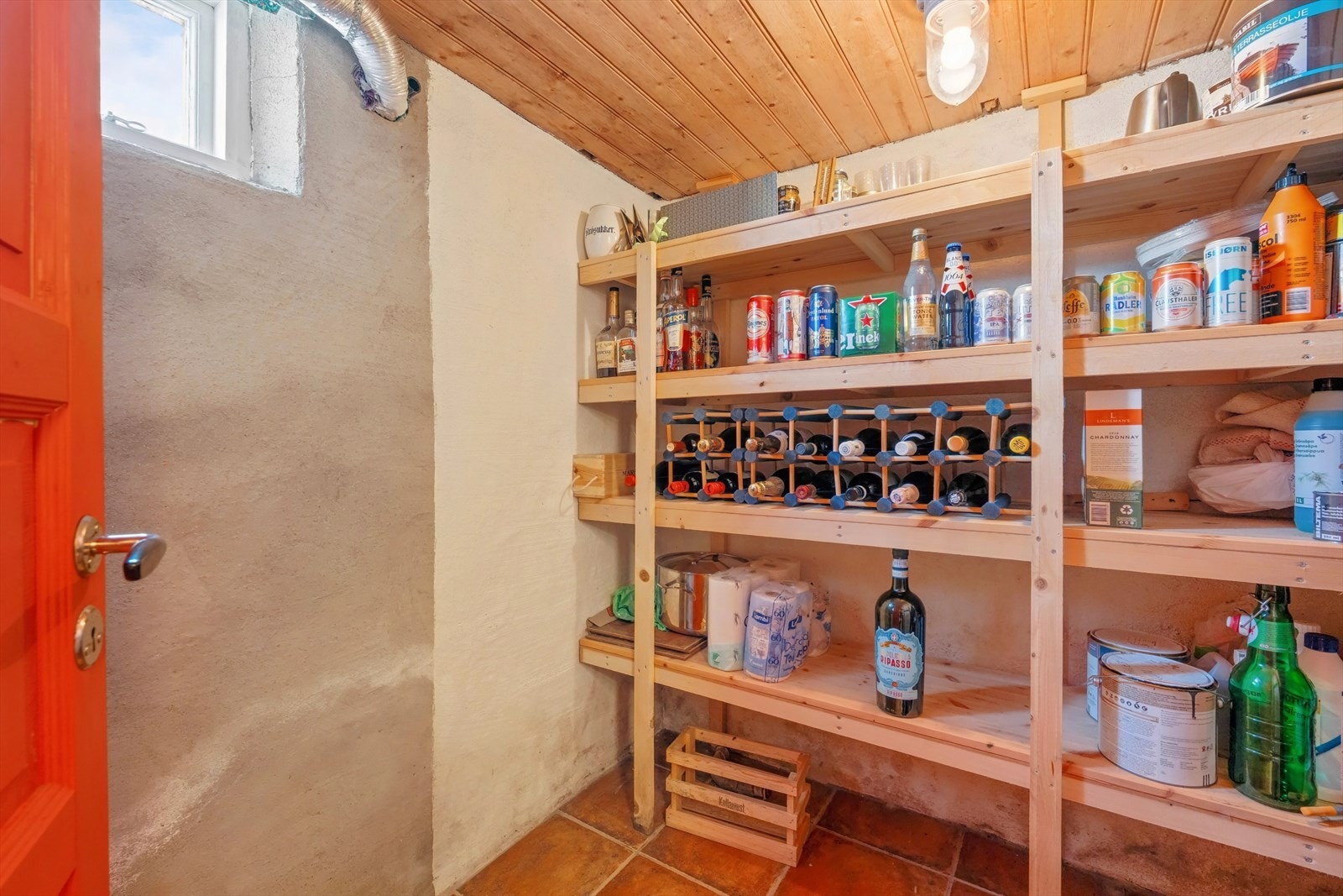 Praktisk bod/ølkjeller med flislagt gulv og trehyller gir god lagringsplass. Galleribilde