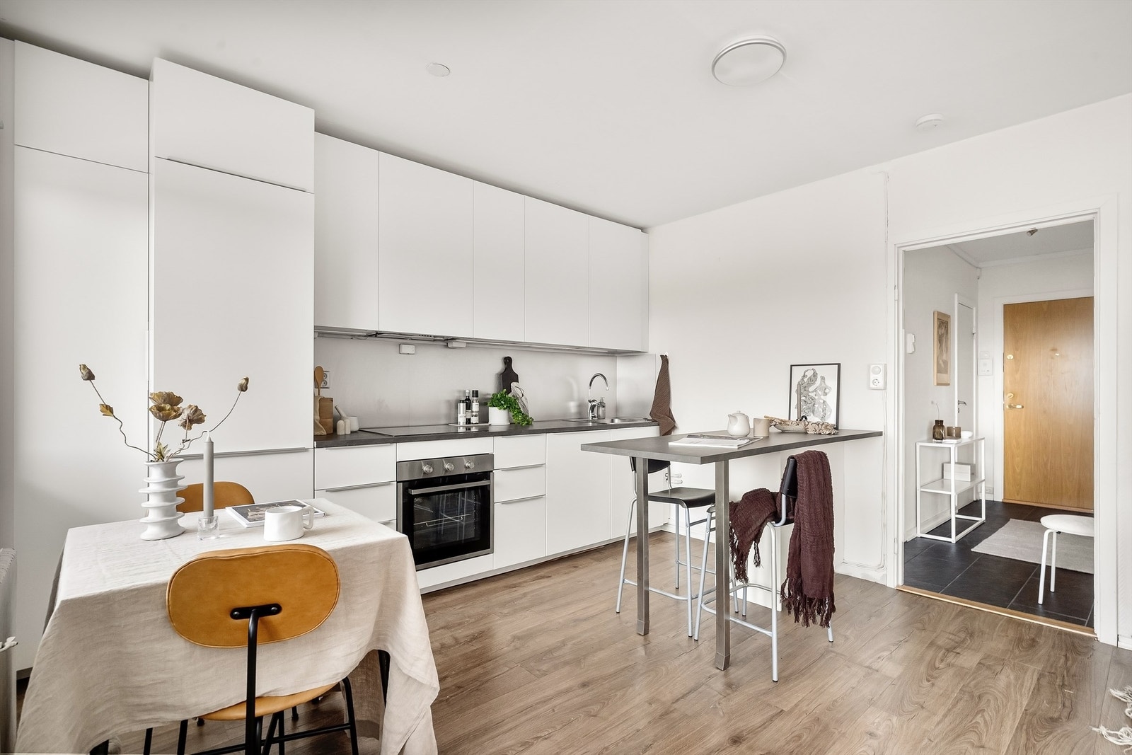 Kjøkkeninnredningen har slette, hvite fronter og benkeplate i laminat. Galleribilde