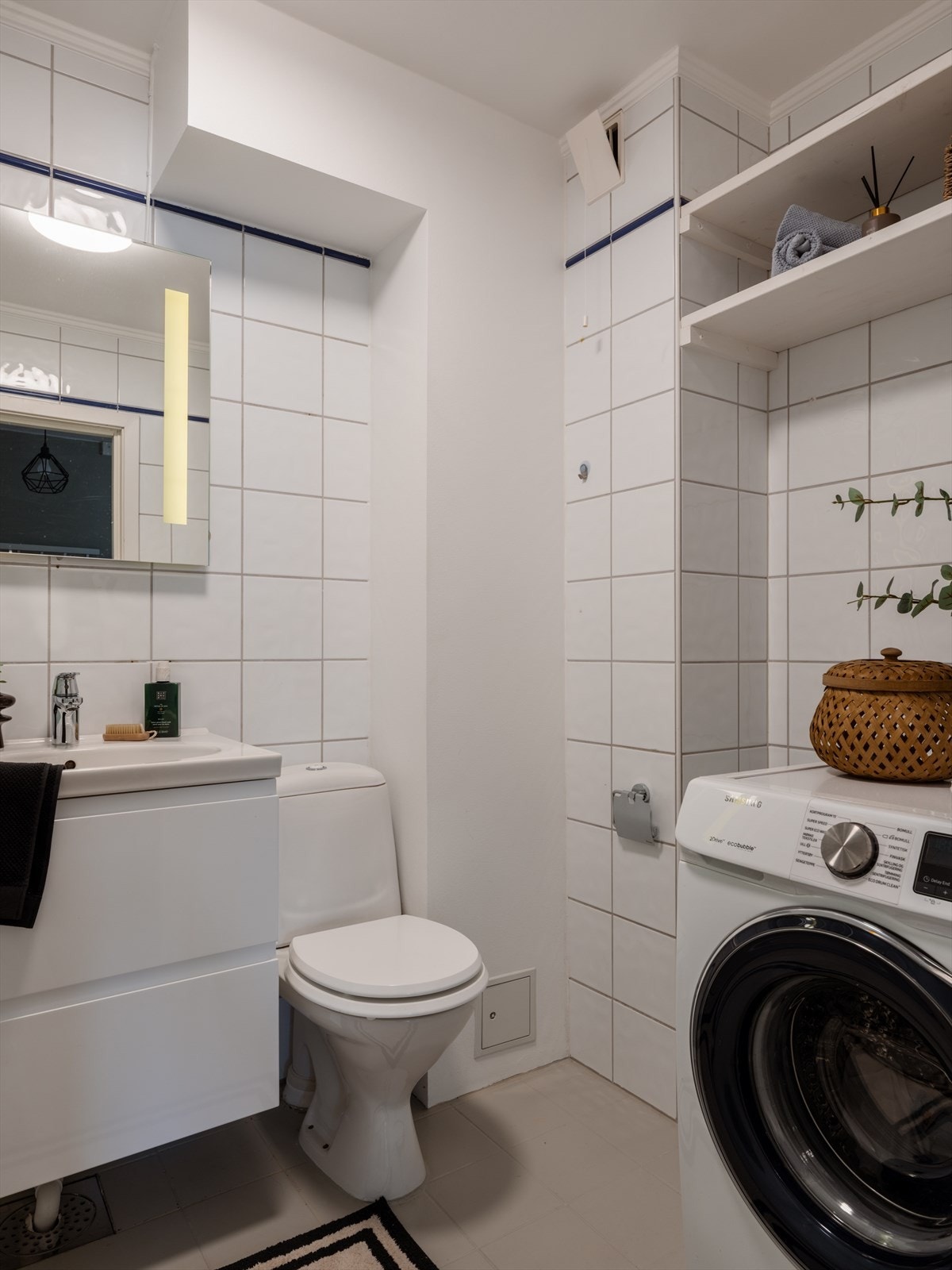 Badet har flislagte vegger, varmekabler i gulvet og opplegg for vaskemaskin. Galleribilde