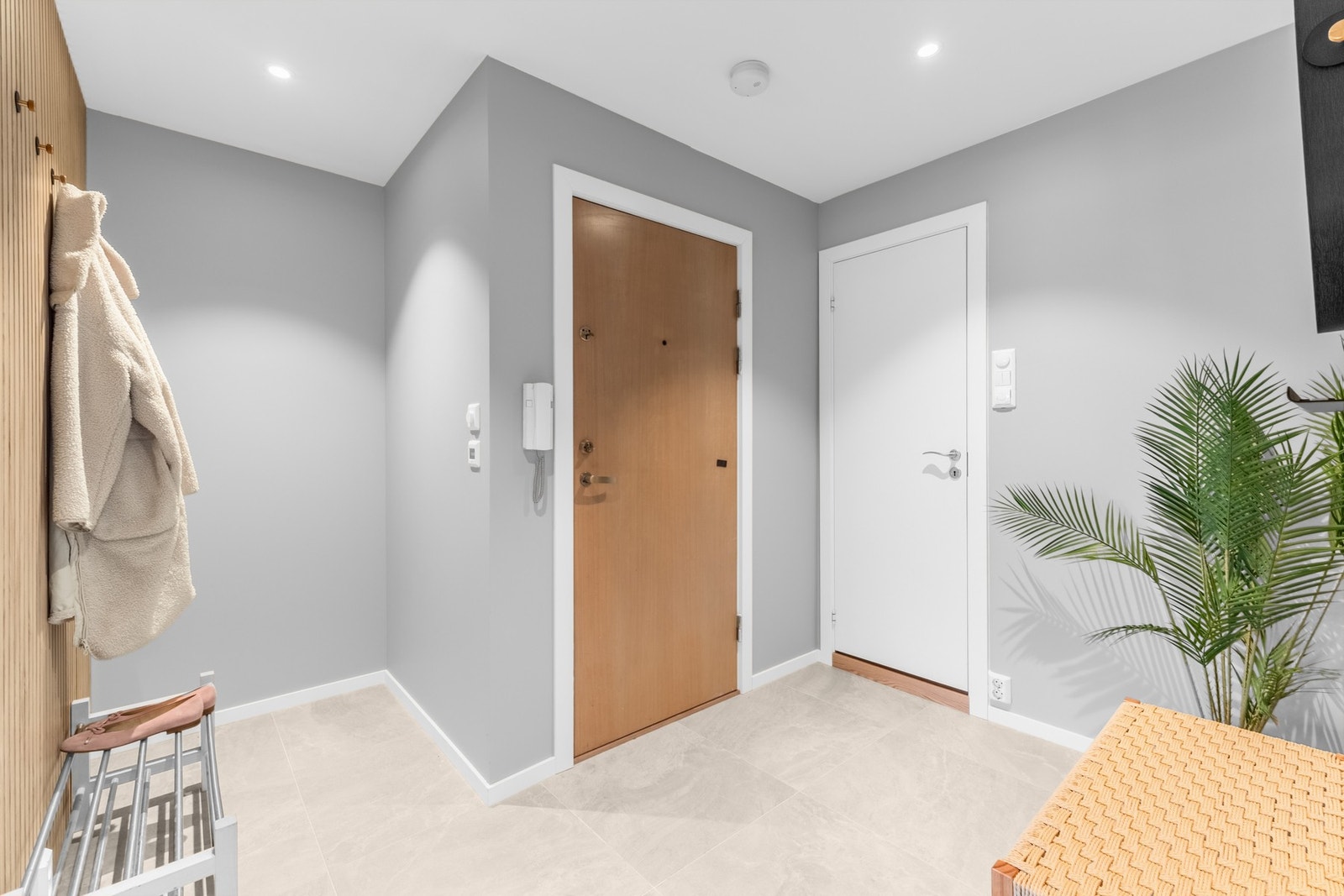 Nyoppusset entré med flislagt gulv med varmekable, lydisolert tak samt stilrene materialvalg Galleribilde