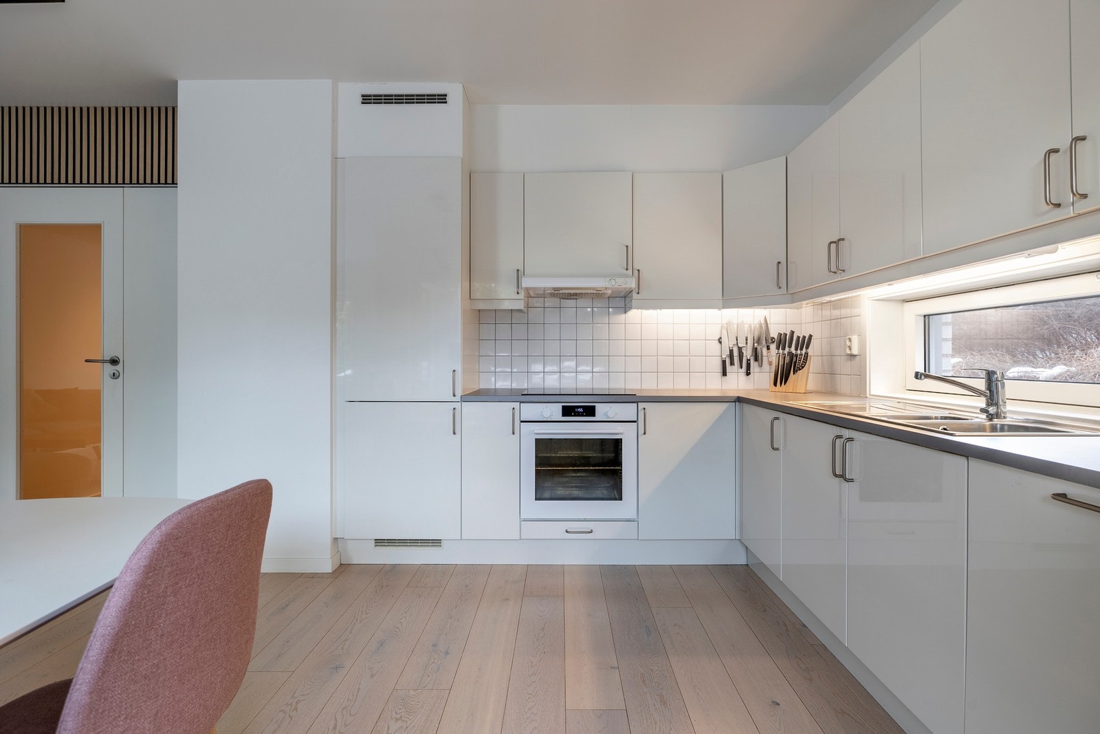 Kjøkkenet er utstyrt med integrerte hvitevarer som induksjonstopp, komfyr, oppvaskmaskin og kjøleskap med frysedel. Galleribilde