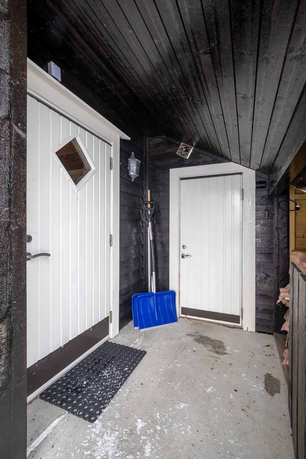 Overbygd inngangsparti - her kan du gå tørrskodd til uteboden eller for å hente ved Galleribilde