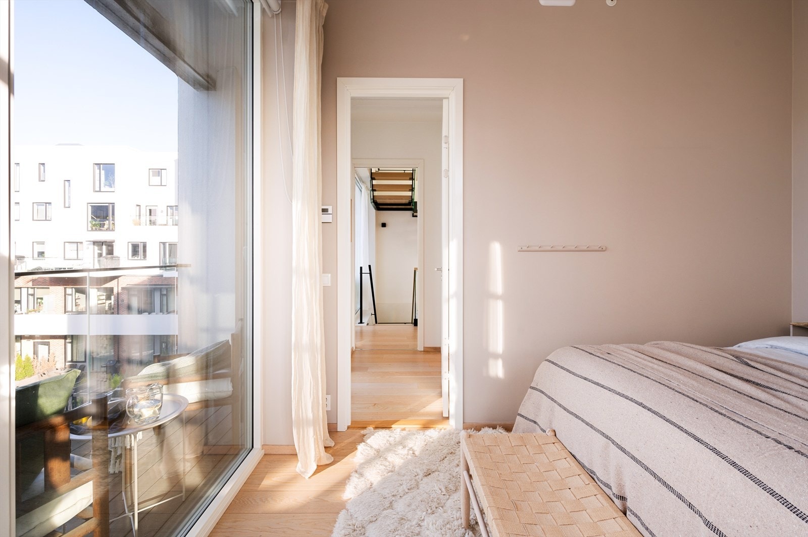 I leilighetens andre etasje ligger et lyst og innbydende soverom som på elegant vis kombinerer komfort og stil. Galleribilde