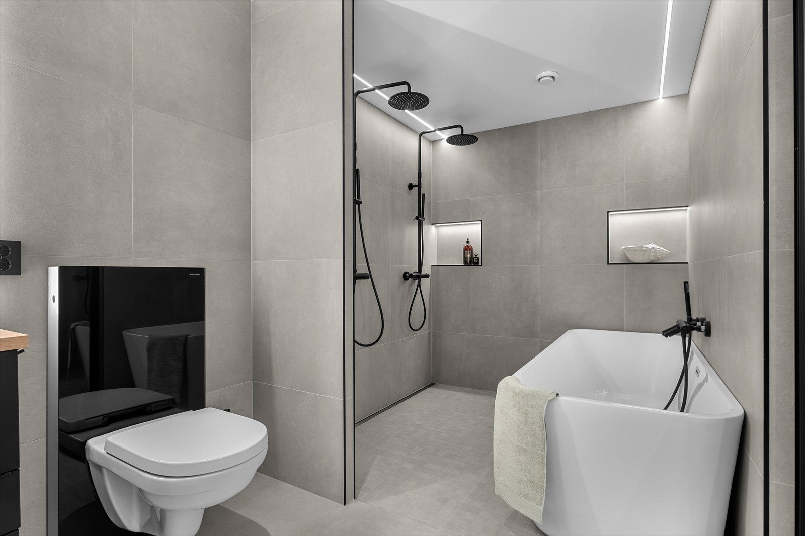 I tillegg byr badet på veggmontert toalett, samt en luksuriøs dusjinsje med 2 regndusjer og et badekar som går i stil med resten av badet. Galleribilde