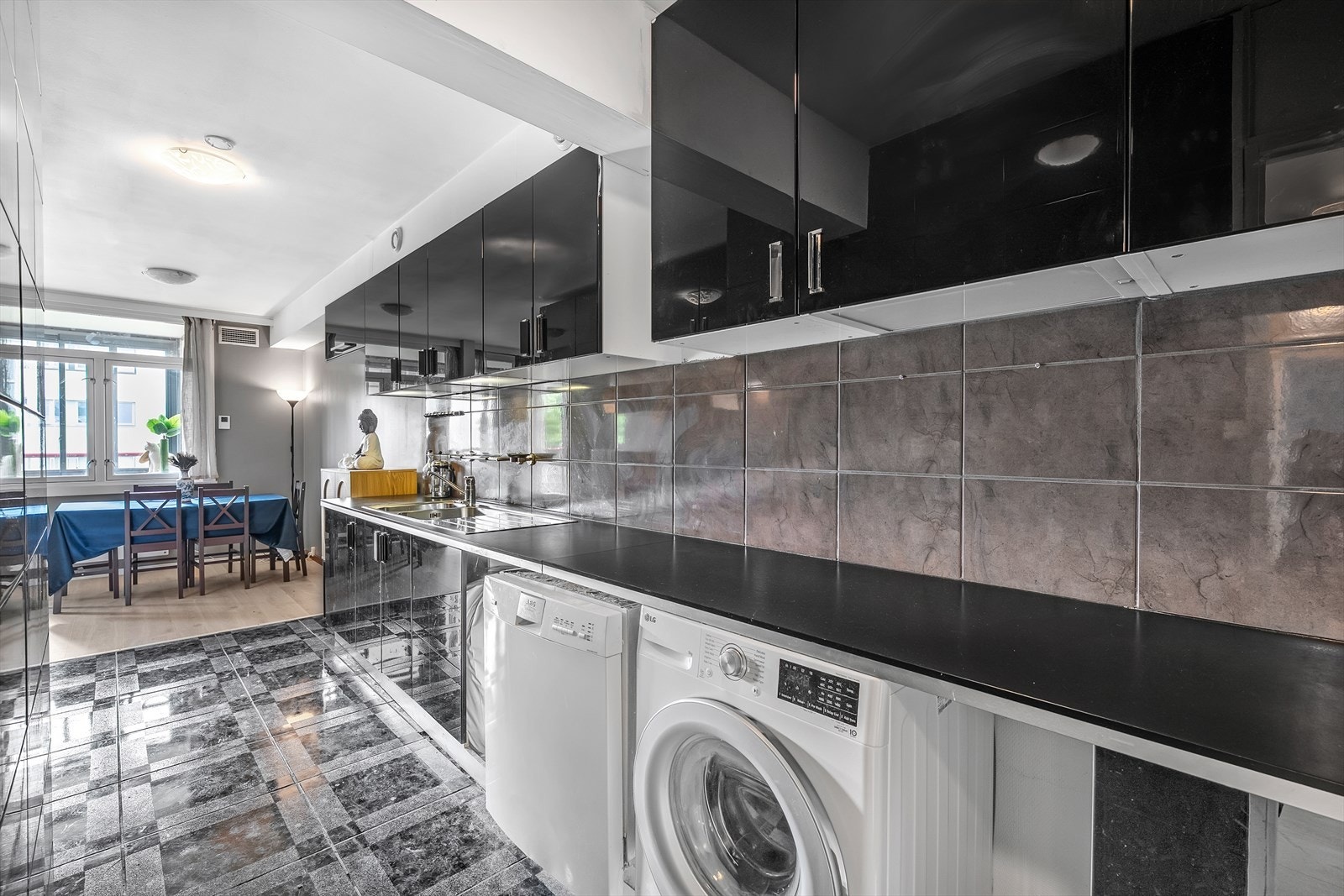 Kjøkken med mye skap og benkeplass. Det er opplegg for kjøleskap, vaskemaskin og oppvaskmaskin Galleribilde