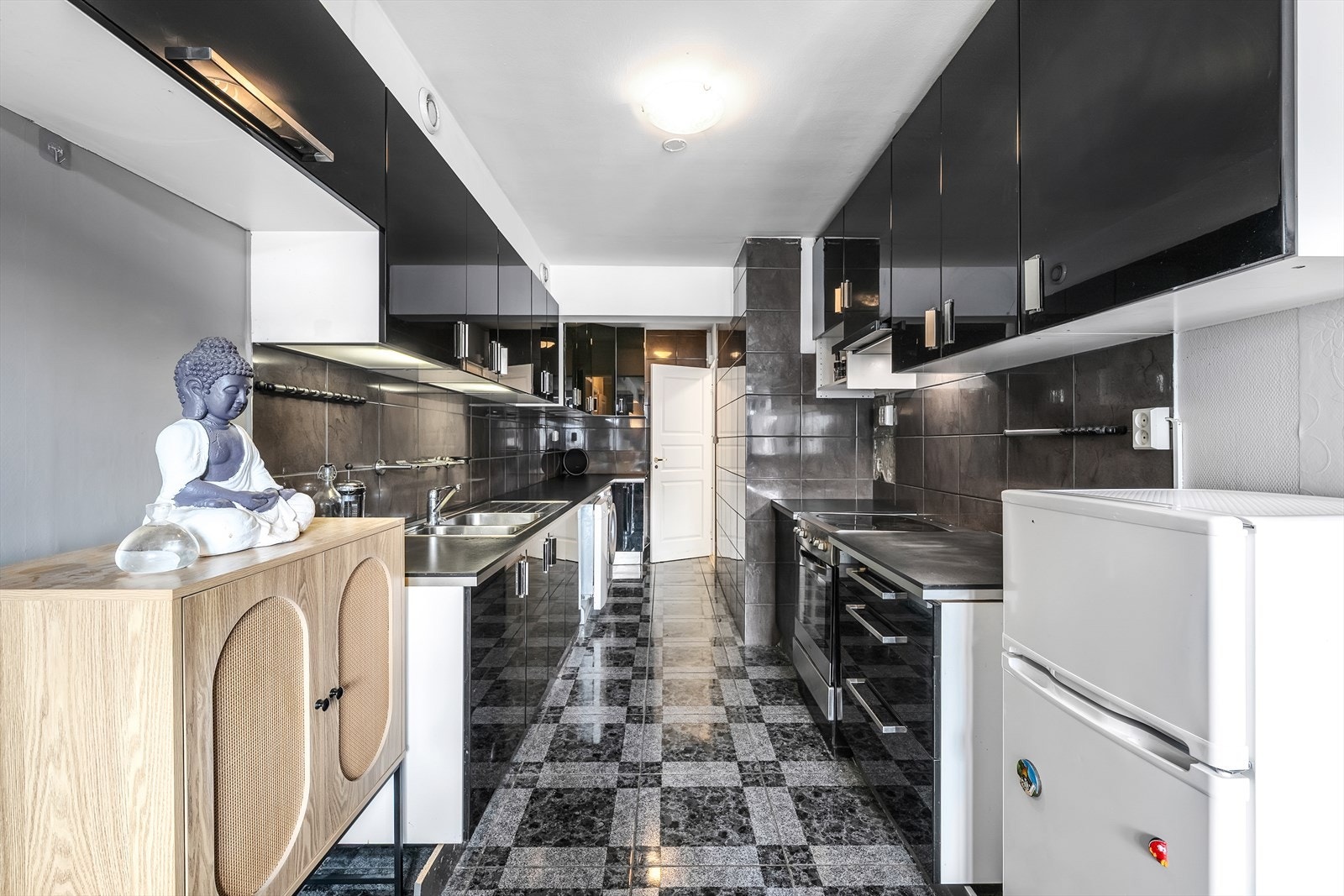 Kjøkkenet har folierte skrog med slette fronter og laminert benkeplate. Det er flis på vegg over benkeplate. Galleribilde